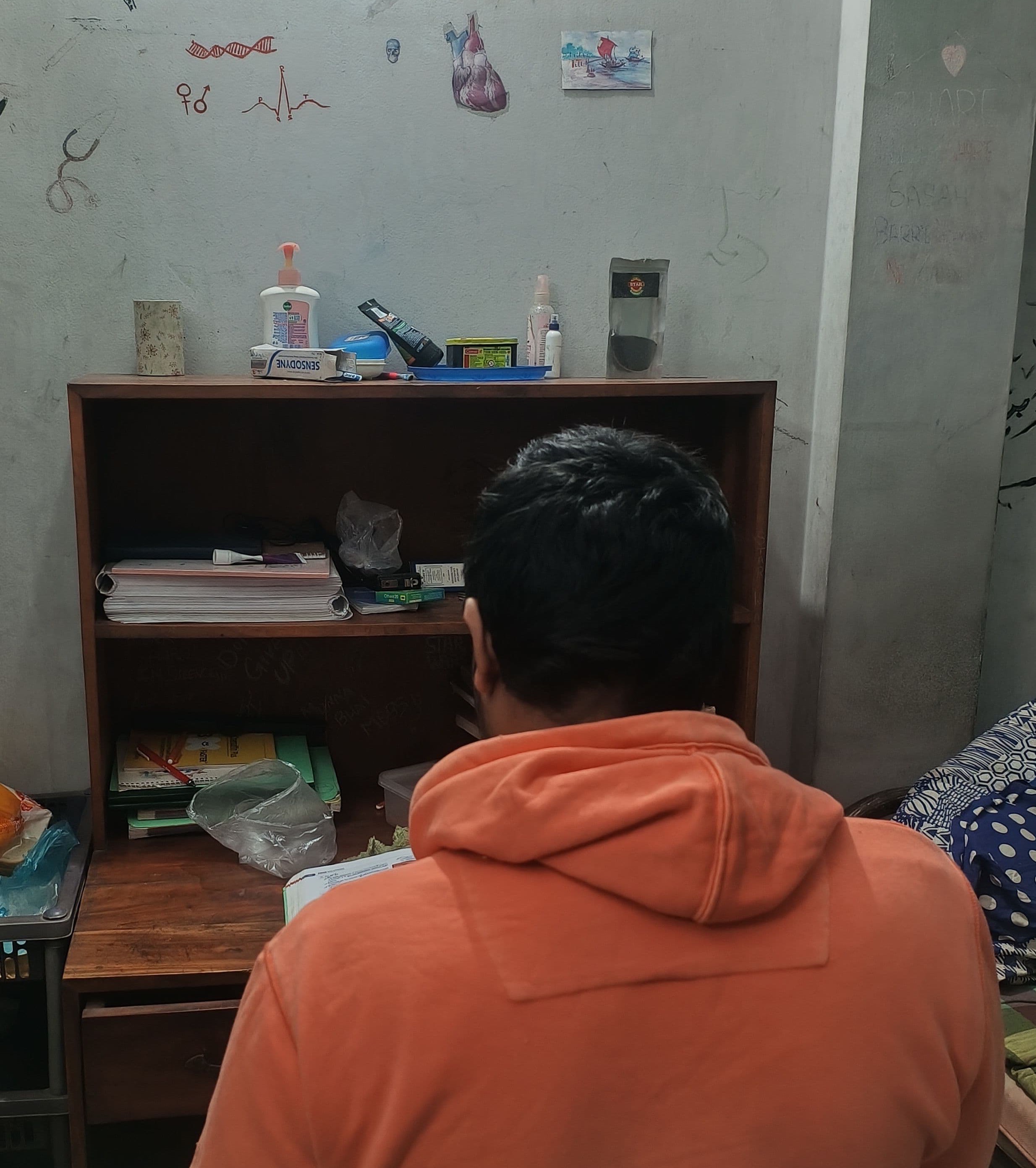 Mohammad, an Indian student at Dhaka Medical College, working at his hostel desk. Mohammad requested that his full name and face not be revealed, for fear of possible retribution from college authorities.