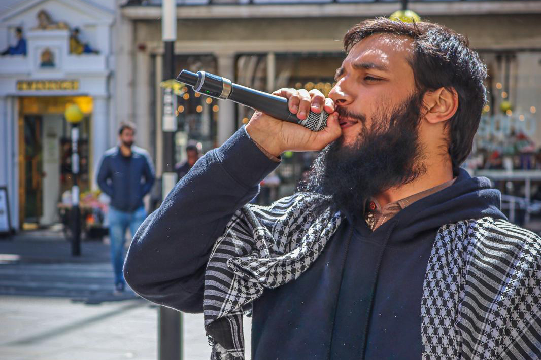 Umer Khalid speaks into a microphone.