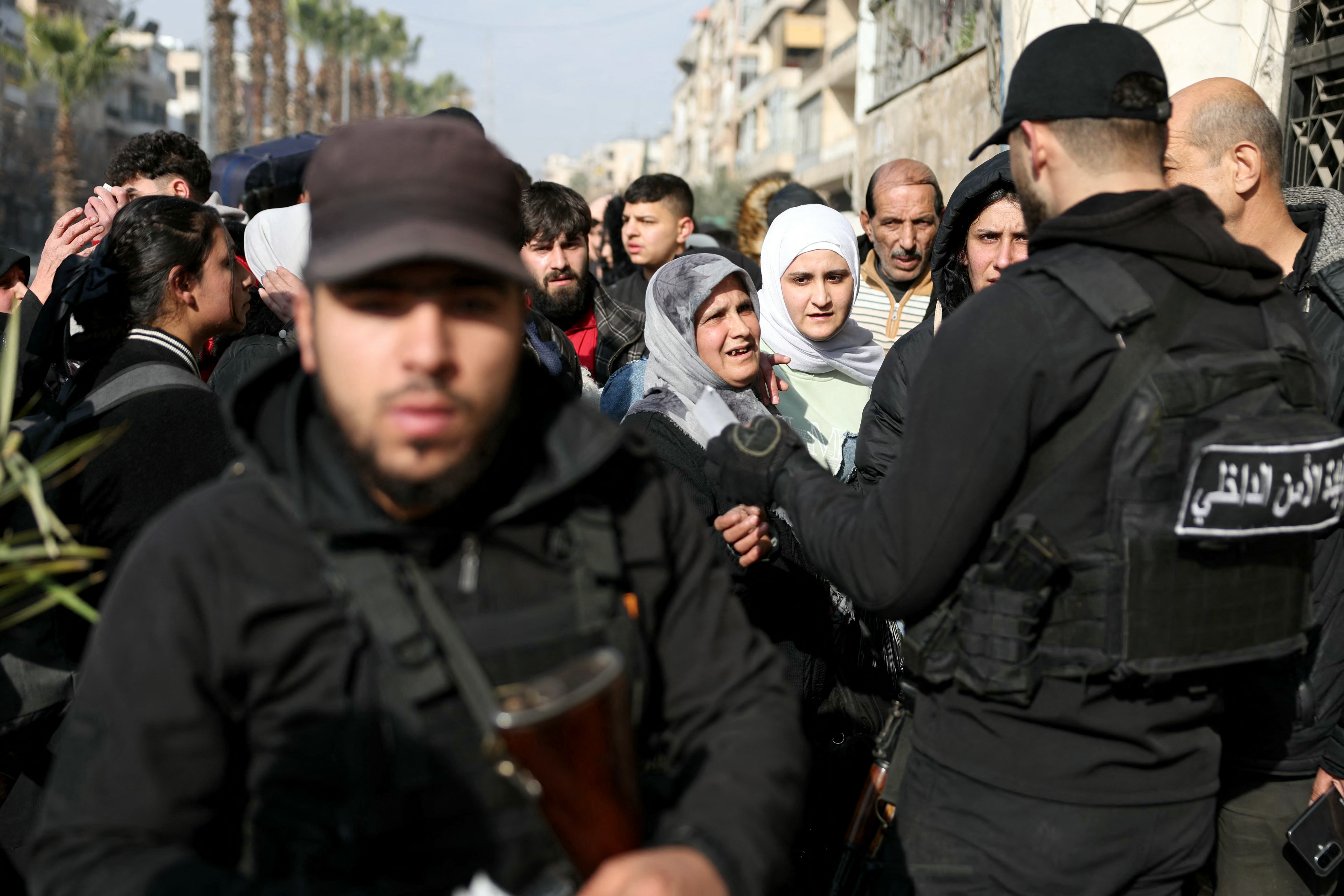 Syrian security forces escort residents fleeing from the fighting.