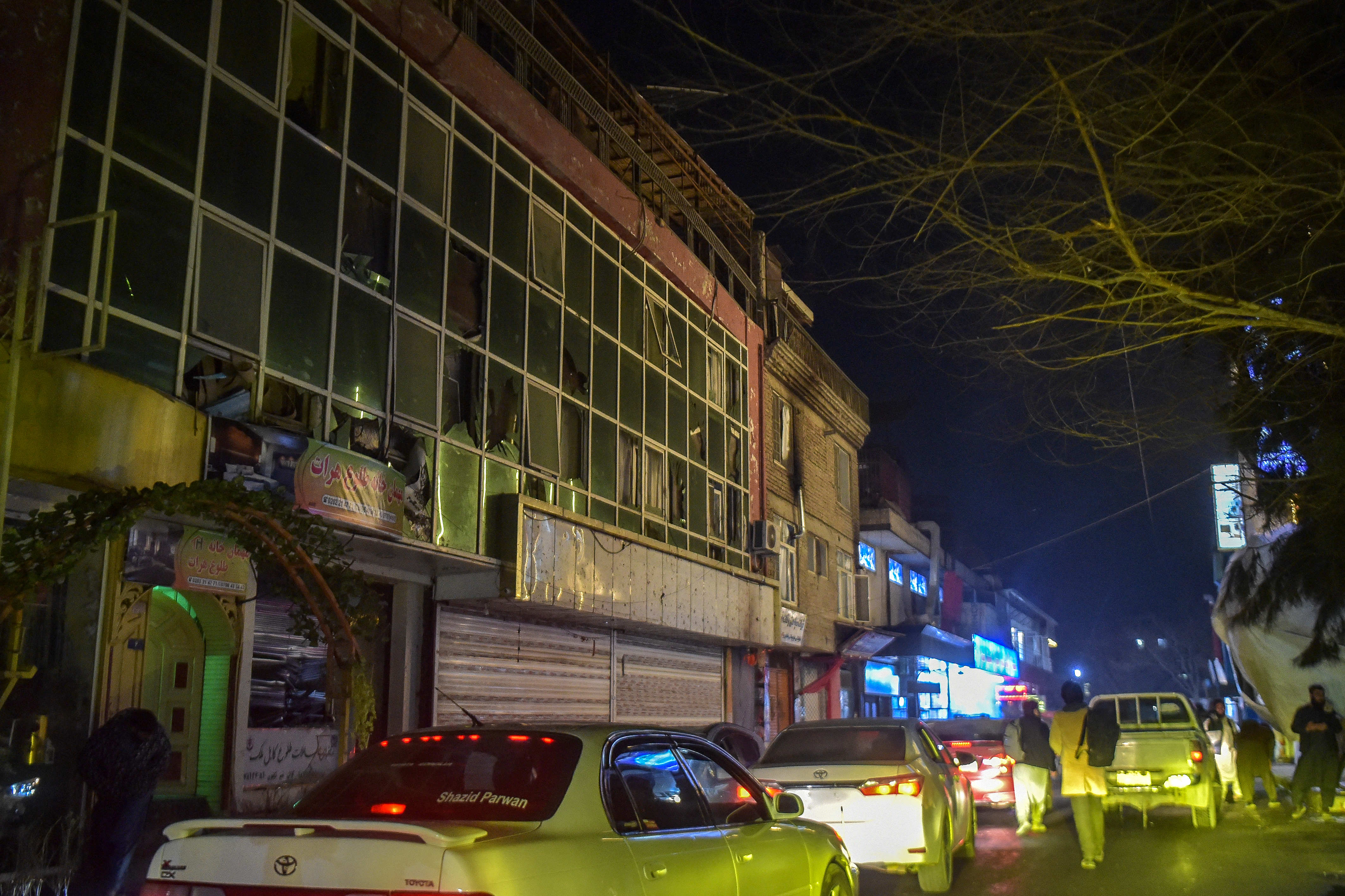 TOPSHOT - Motorists ride past a building with shattered glass following an explosion in the Shahr-e Naw area of Kabul on January 19, 2026.