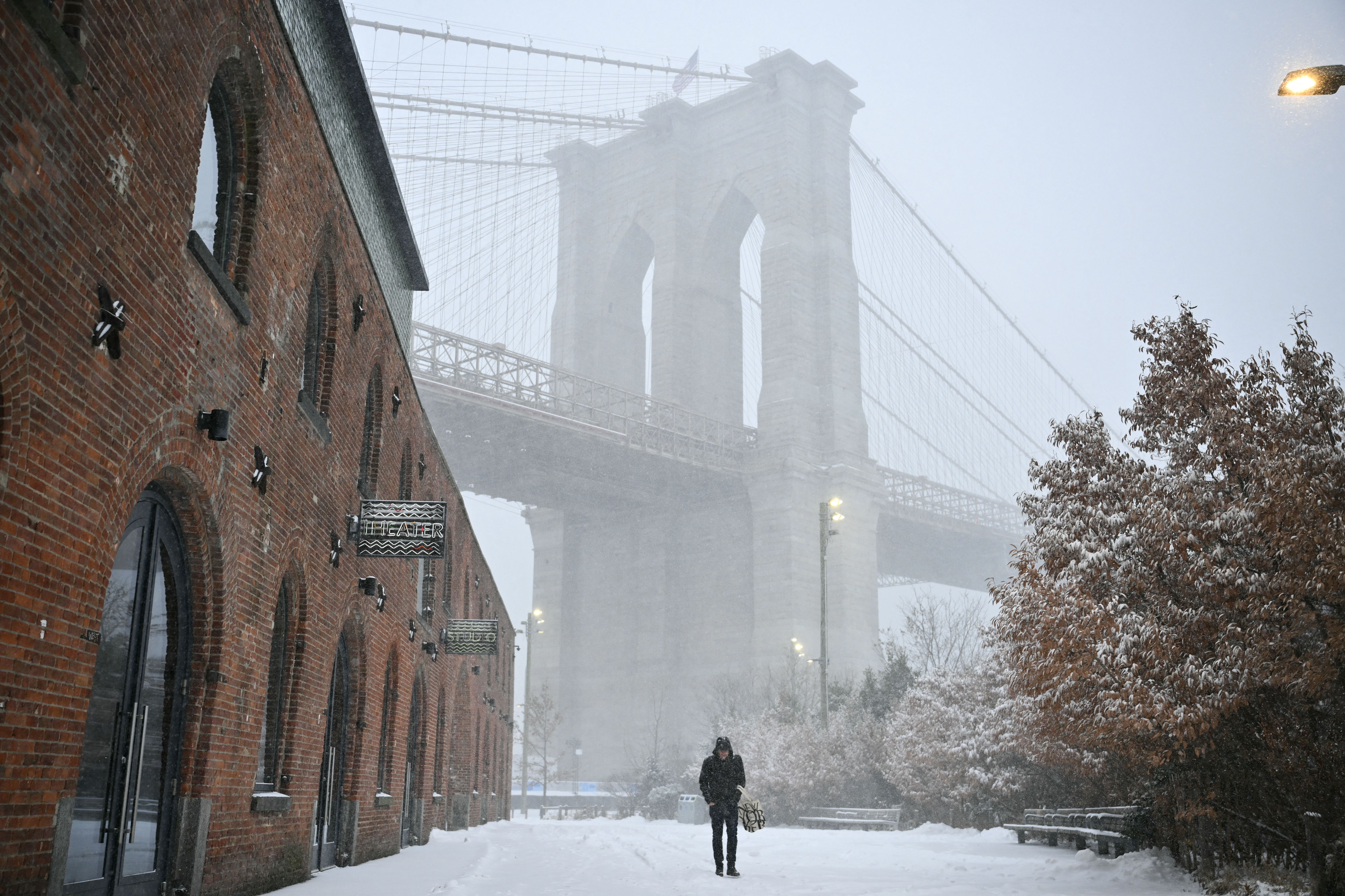 A person walks in the snow near the Brooklyn Bridge in New York City on January 25, 2026.