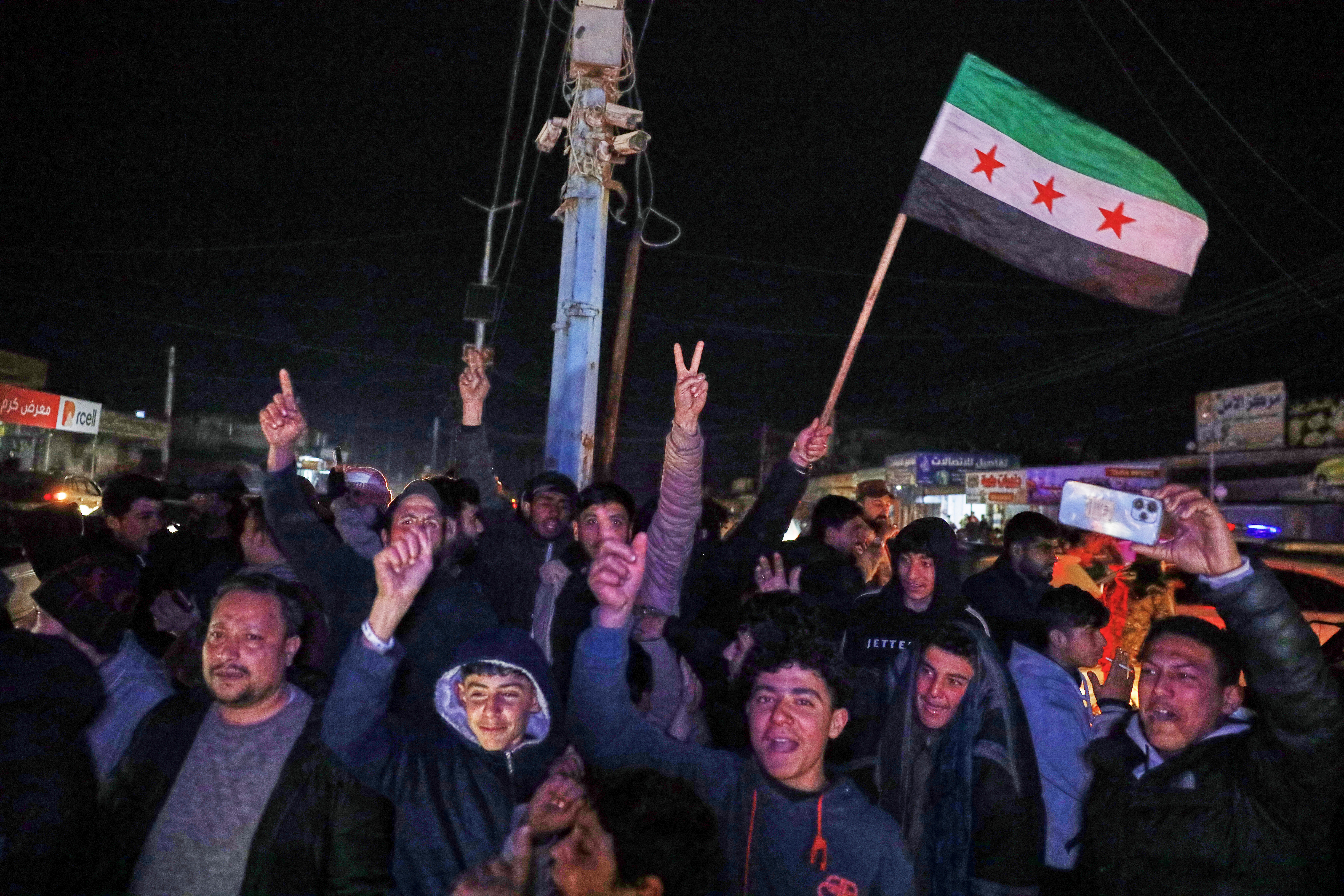 People celebrate as Syrian government troops take control of the town from the Syrian Democratic Forces (SDF), in Raqqa, northeastern Syria, Sunday, Jan. 18, 2026. (AP Photo/Omar Albam)