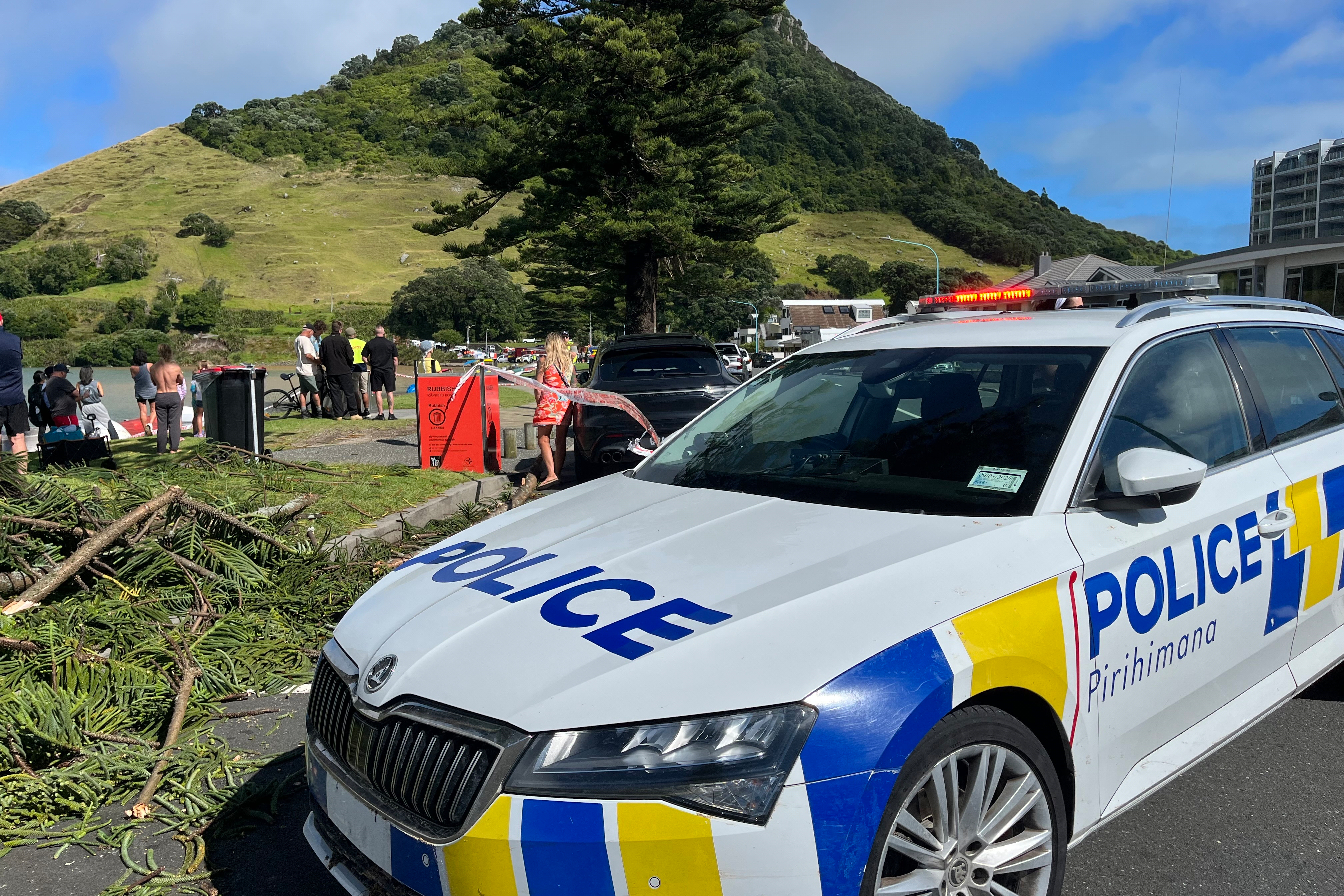 Emergency workers and bystanders survey the scene after a landslide hit a campground at Mt. Maunganui, New Zealand, Thursday, Jan. 22, 2026. (Stuff via AP)