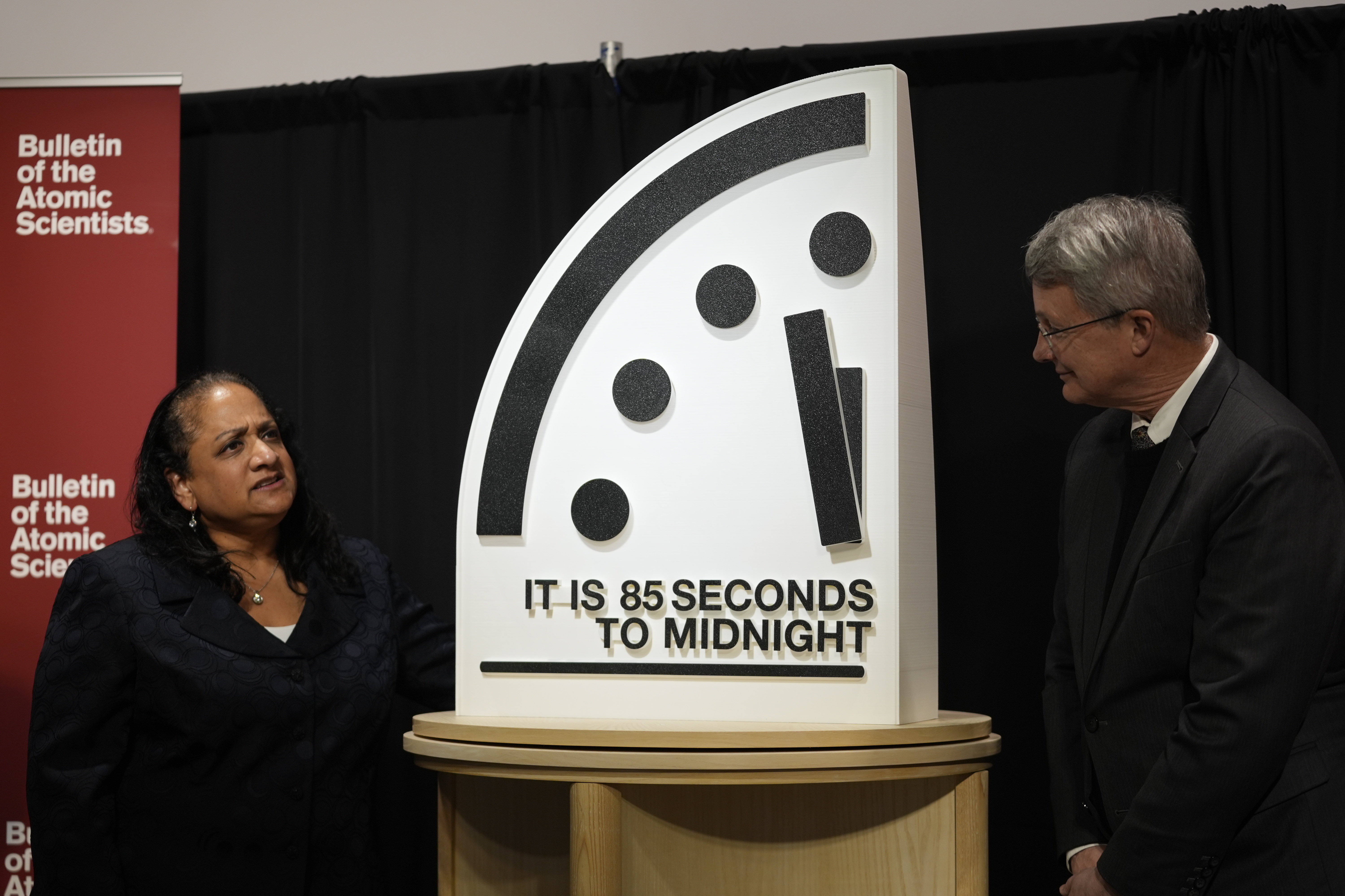The Bulletin of the Atomic Scientists members, Asha M. George, left, and Steve Fetter, right, stand next to the Doomsday Clock, set to 85 seconds to midnight, during a news conference at the Carnegie Endowment for International Peace, Friday, Jan. 23, 2026, in Washington. (AP Photo/Pablo Martinez Monsivais)