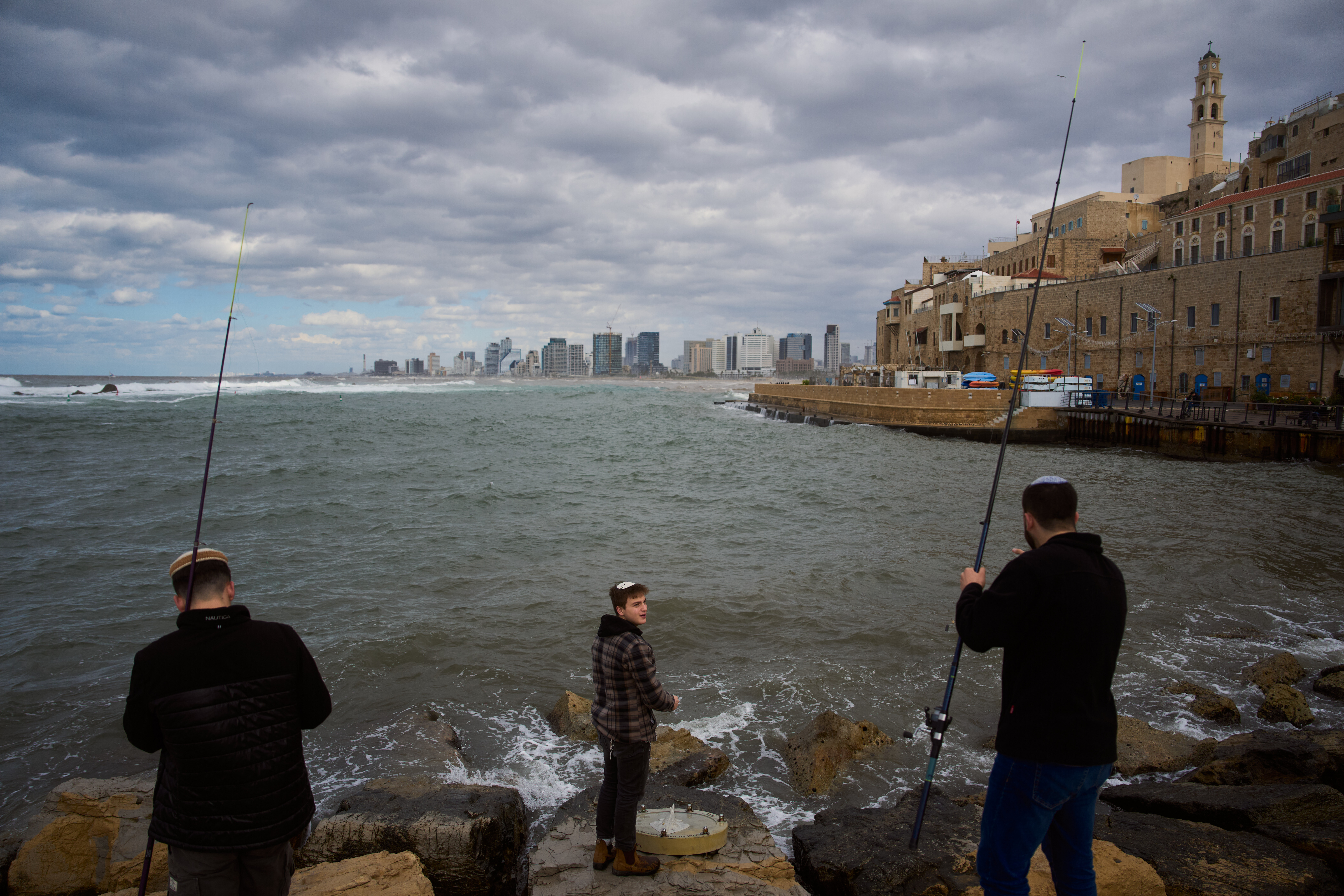 Israeli youths cast fishing rods from a pier at the old port of Jaffa, a mixed Jewish-Arab area of Tel Aviv, Israel, Friday, Jan. 2, 2026. (AP Photo/Oded Balilty)