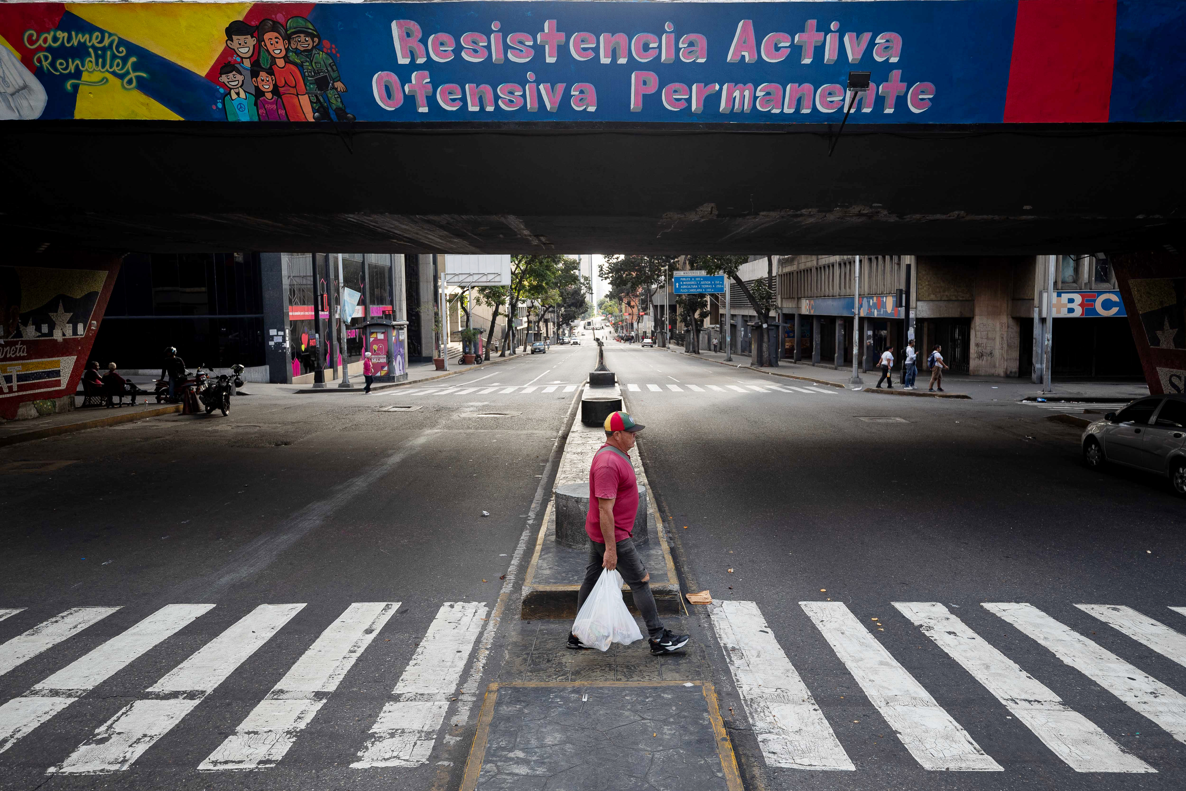 epaselect epa12626255 A man crosses a quiet street in Caracas, Venezuela, 04 January 2026. US forces captured Venezuelan President Nicolas Maduro and his wife, Cilia Flores, in a military operation on 03 January 2026. President Maduro and his wife were transported to New York following an indictment issued by the Southern District of New York. EPA/RONALD PENA R