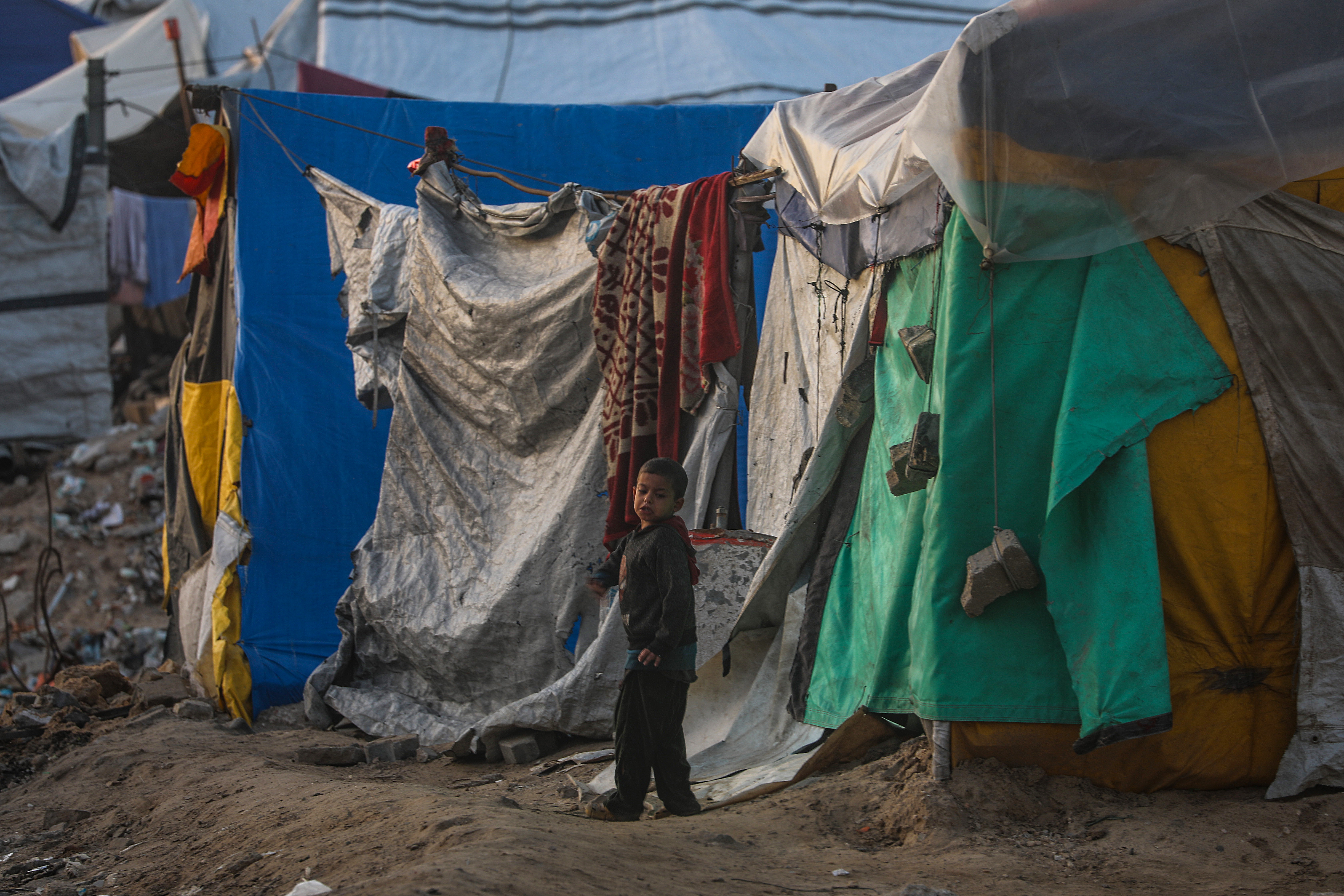 epa12632561 An internally displaced Palestinian boy plays next his family shelter at Al Rashid road in the west of Gaza City on, 06 January 2026, amid a ceasefire between Israel and Hamas. Around 1.9 million people in Gaza, nearly 90 percent of the population, have been displaced since the Israel-Hamas conflict began in October 2023, according to the UN. EPA/MOHAMMED SABER