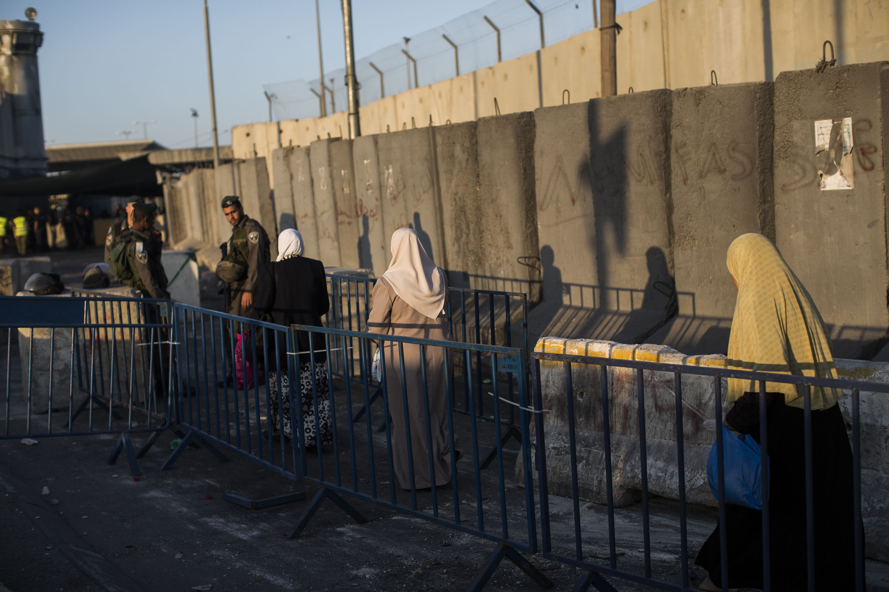 RAMALLAH, WEST BANK - JULY 04: Palestinian Muslim worshippers cross the Qalandia checkpoint on their way to Jerusalem on July 4, 2014 near Ramallah, West Bank. Usually thousands of Palestinian worshippers cross from the West Bank into Israel to attend the first Friday prayers of Ramadan at the Al-Aqsa mosque compound in Jerusalem, however this year due to an age restriction not many people attended the crossing. The age limit was set because of an escalation of violence after the discovery of the body of a Palestinian boy earlier this week, suspected of being a revenge killing for the murder of three Jewish teenagers in the West Bank. (Photo by Ilia Yefimovich/Getty Images)
