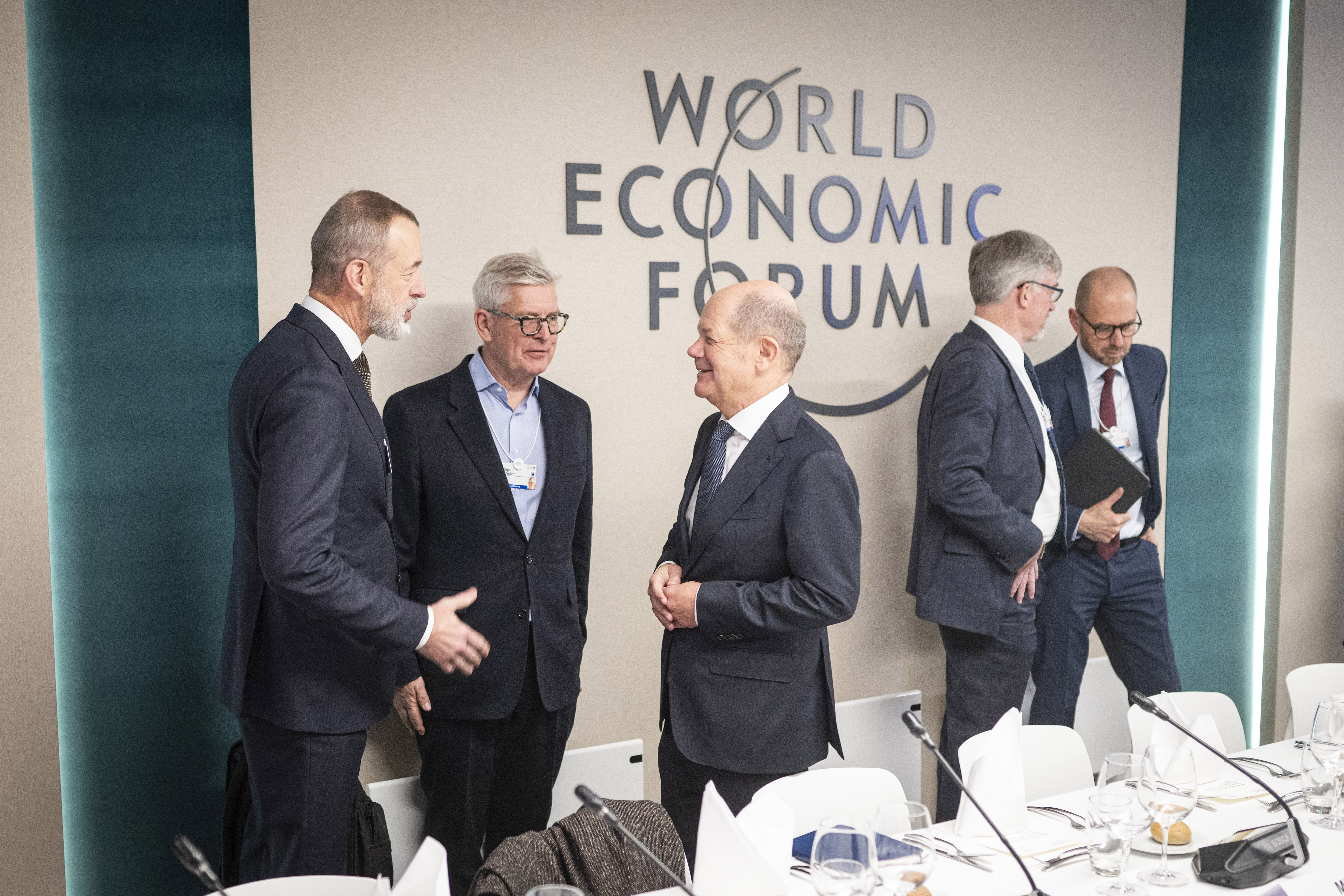 DAVOS, SWITZERLAND - JANUARY 21: (EDITOR’S NOTE: This Handout image was provided by a third-party organization and may not adhere to Getty Images’ editorial policy.) In this handout image provided by the German Government Press Office (BPA), German Chancellor Olaf Scholz (C) speaks to (from left) Boudewijn Siemons, CEO of the Rotterdam Port Authority, Börje Ekholm, CEO of Ericsson, Blake Moret, CEO Rockwell Automation, Christian Bruch, CEO of Siemens Energy AG during a working lunch with international entrepreneurs at the World Economic Forum (WEF) annual meeting on January 21, 2025 in Davos, Switzerland. (Photo by Guido Bergmann/Bundesregierung via Getty Images)