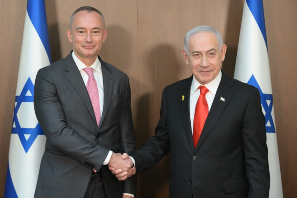 Israeli Prime Minister Benjamin Netanyahu (R) shakes hands and poses for a photo with Nickolay Mladenov.