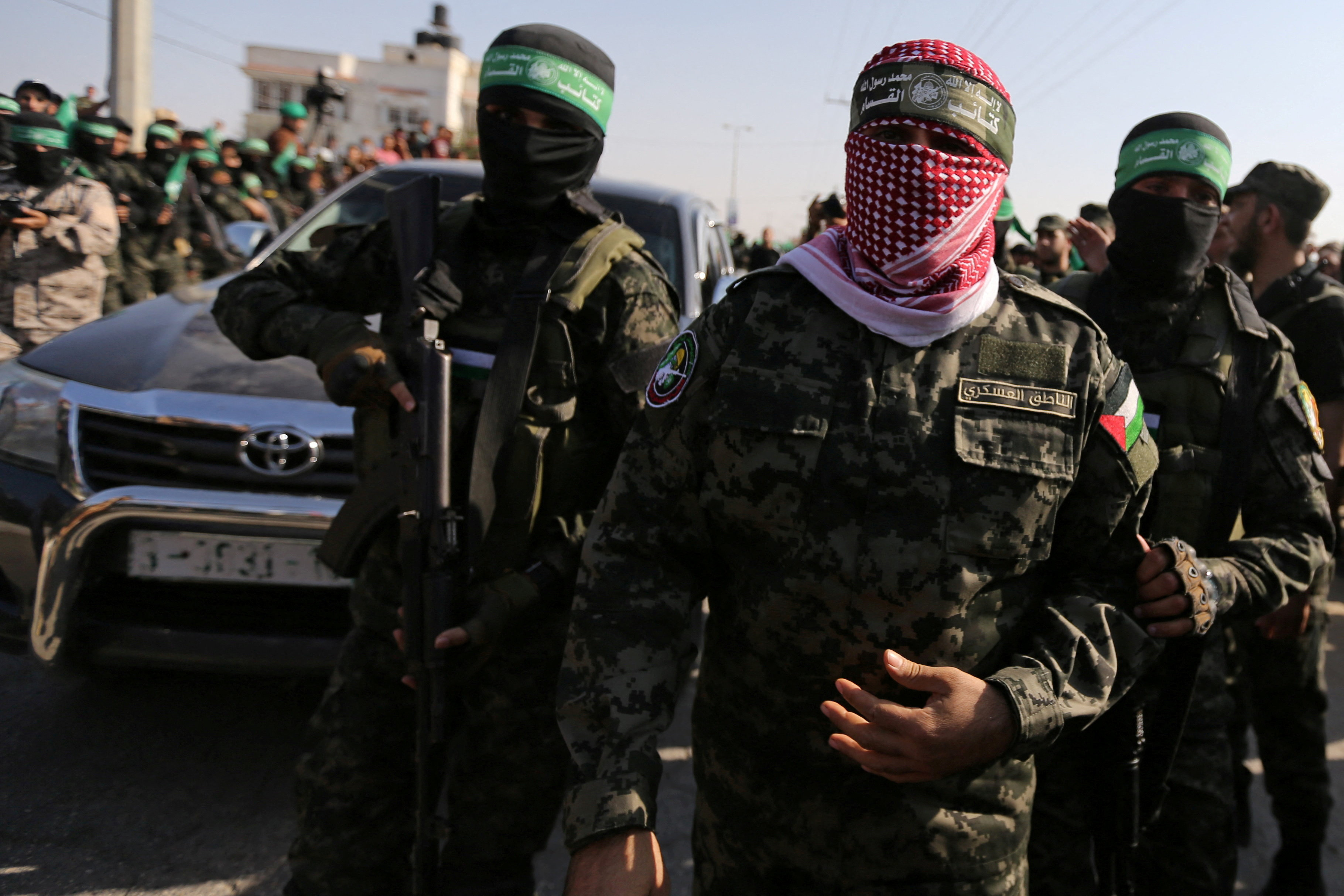 Abu Ubaida, the spokesman of the Qassam Brigades, walks with other Hamas fighters.