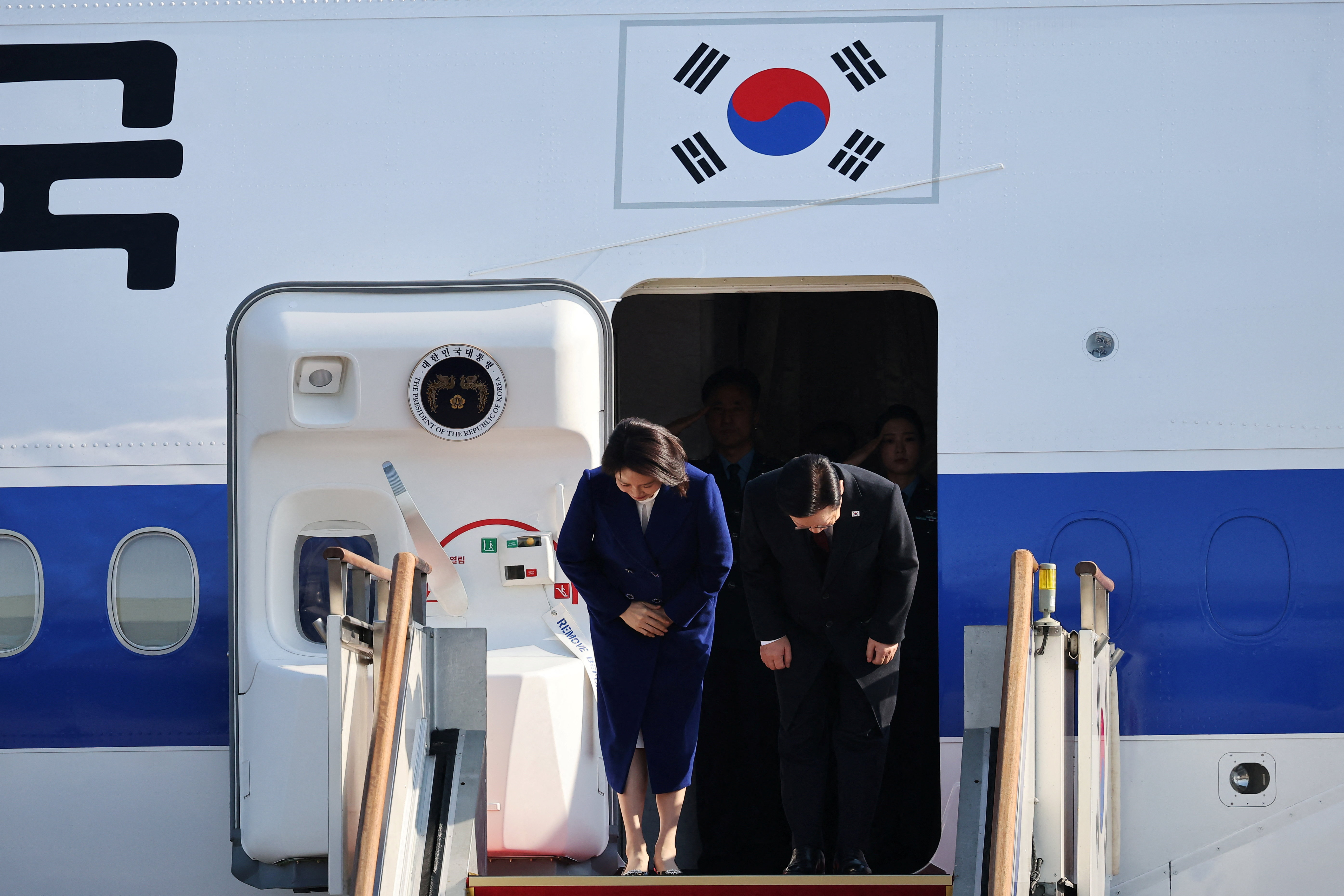 South Korean President Lee Jae Myung and his wife Kim Hye-kyung bow at Seoul Air base as they leave for Beijing, in Seongnam, South Korea, January 4, 2026. REUTERS/Kim Hong-Ji