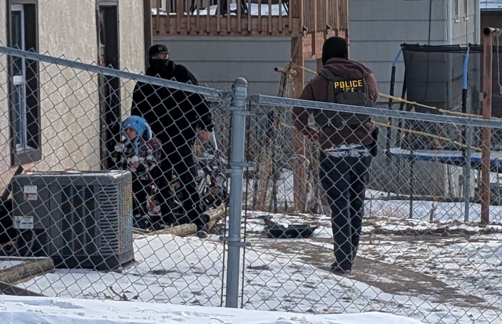 ICE agents stand next to a boy, who a witness identified as Liam Conejo Ramos, a five-year-old that school officials said was detained in Minneapolis, Minnesota, U.S., January 20, 2026. Rachel James/via REUTERS THIS IMAGE HAS BEEN SUPPLIED BY A THIRD PARTY. MANDATORY CREDIT. Reuters verified the location from the road layout, buildings, and fence seen in the video and photographs which matched file and satellite imagery of the area. The date when the visuals were filmed was confirmed by the original file metadata. The school district officials said that a five-year-old was detained on Tuesday (January 20). The Department of Homeland Security said they attempted to apprehend the father of the boy on Tuesday (January 20.). THIS PICTURE WAS CROPED BY REUTERS. AN UNCROPED VERSION HAS BEEN PROVIDED SEPARATELY. TPX IMAGES OF THE DAY