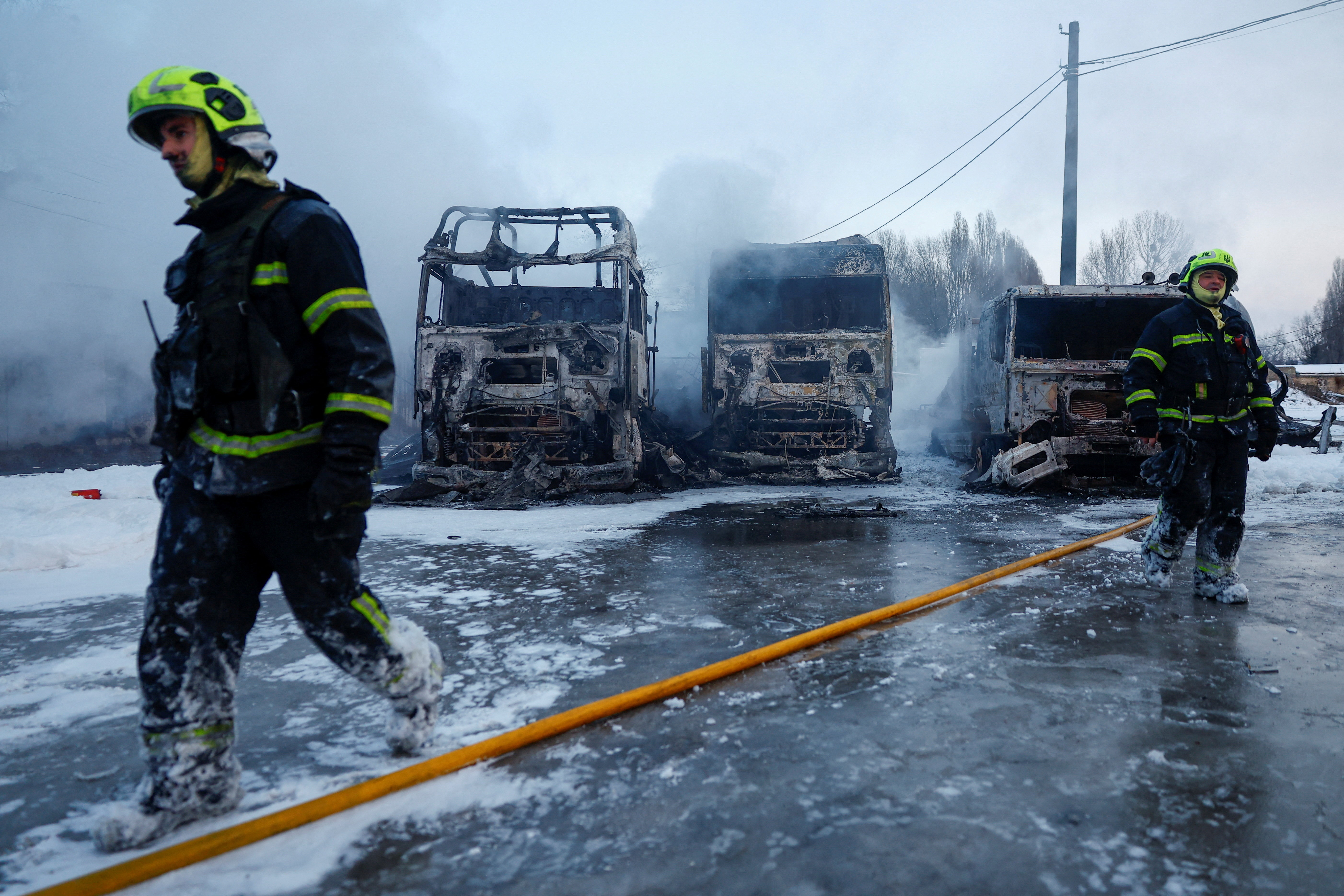 Firefighters walk in front of semi-trucks destroyed during Russian overnight drone and missile strikes, amid Russia's attack on Ukraine, in Kyiv, Ukraine January 24, 2026. REUTERS/Valentyn Makarenko TPX IMAGES OF THE DAY