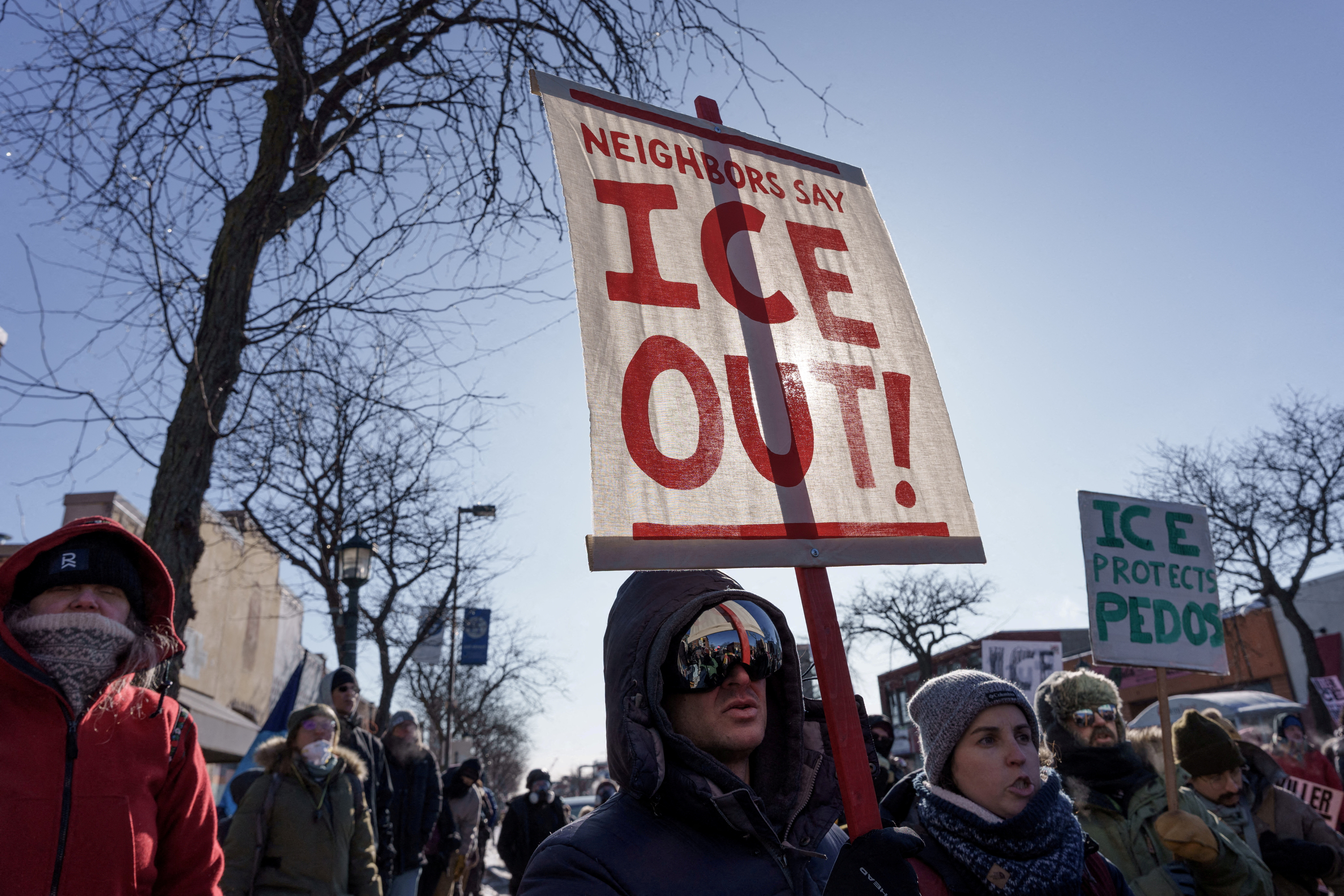 FILE PHOTO: Demonstrators carry signs condemning Immigration and Customs Enforcement (ICE) near the site where a man identified as Alex Pretti was fatally shot by federal agents trying to detain him, in Minneapolis, Minnesota, U.S., January 24, 2026. REUTERS/Tim Evans/File Photo