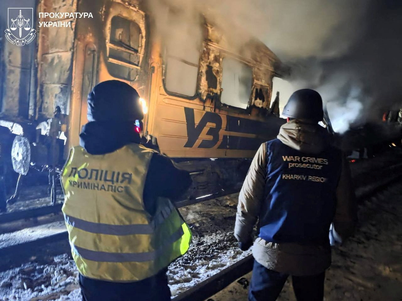 A war crime prosecutor and a police officer work next to a passenger train hit by a Russian drone strike, amid Russia's attack on Ukraine, in Kharkiv region, Ukraine, January 27, 2026. Press service of Kharkiv Regional Prosecutor's Office/Handout via REUTERS ATTENTION EDITORS - THIS IMAGE HAS BEEN SUPPLIED BY A THIRD PARTY. DO NOT OBSCURE LOGO. NO RESALES. NO ARCHIVES.