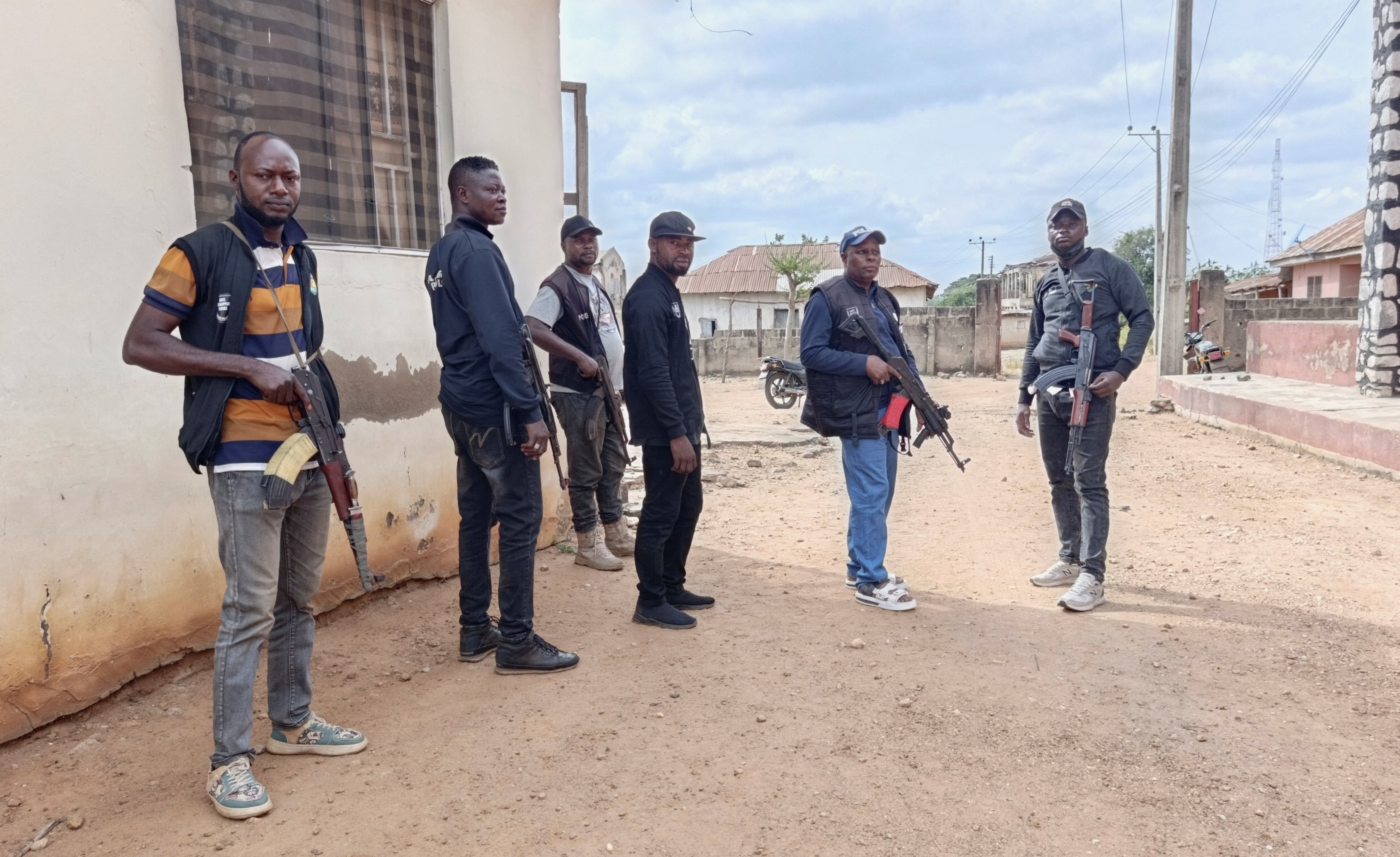 Police officers hold weapons outside a church.