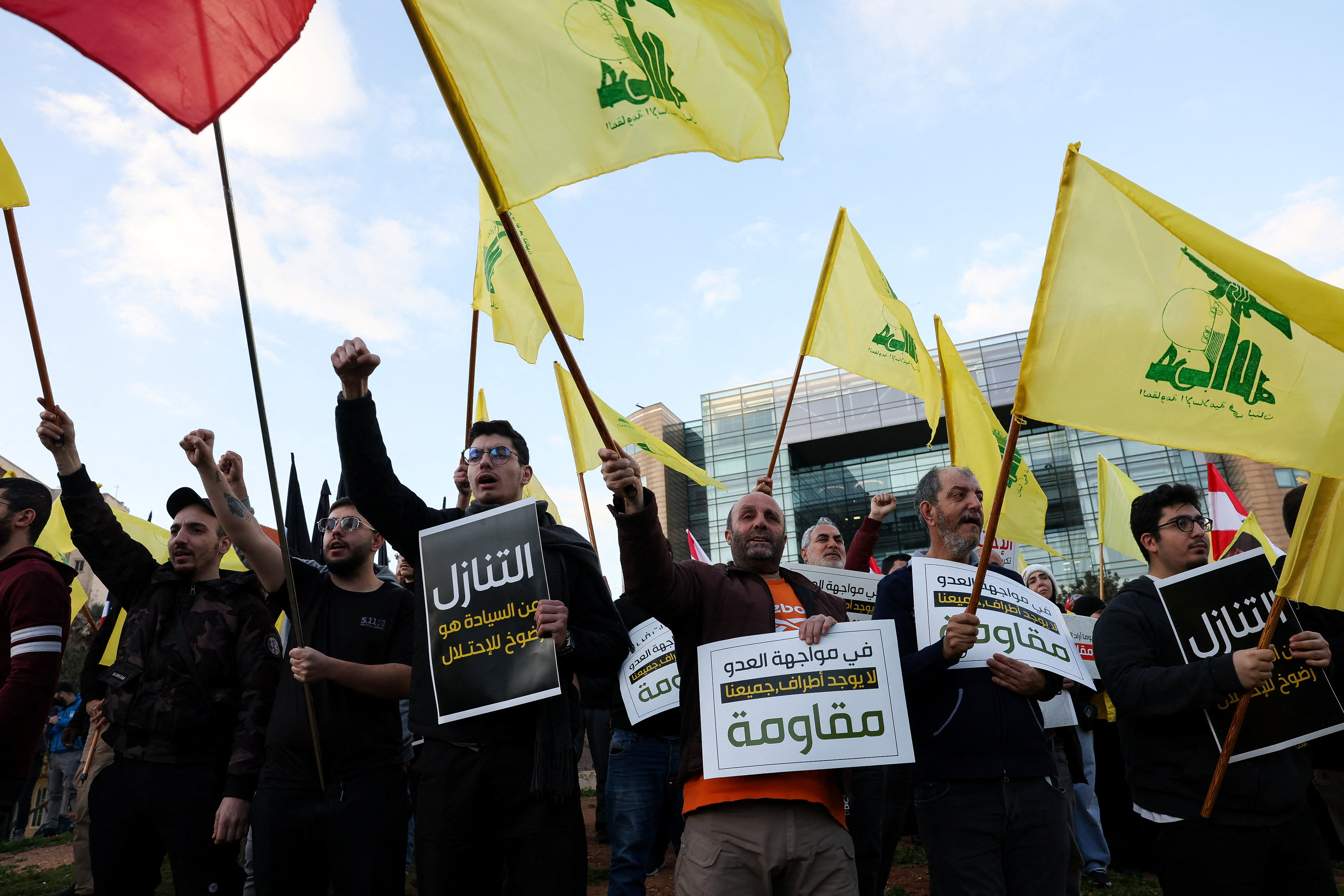 Protesters hold placards and Hezbollah flags during a demonstration condemning recent Israeli military actions in Lebanon, in Beirut, Lebanon February 4, 2026.