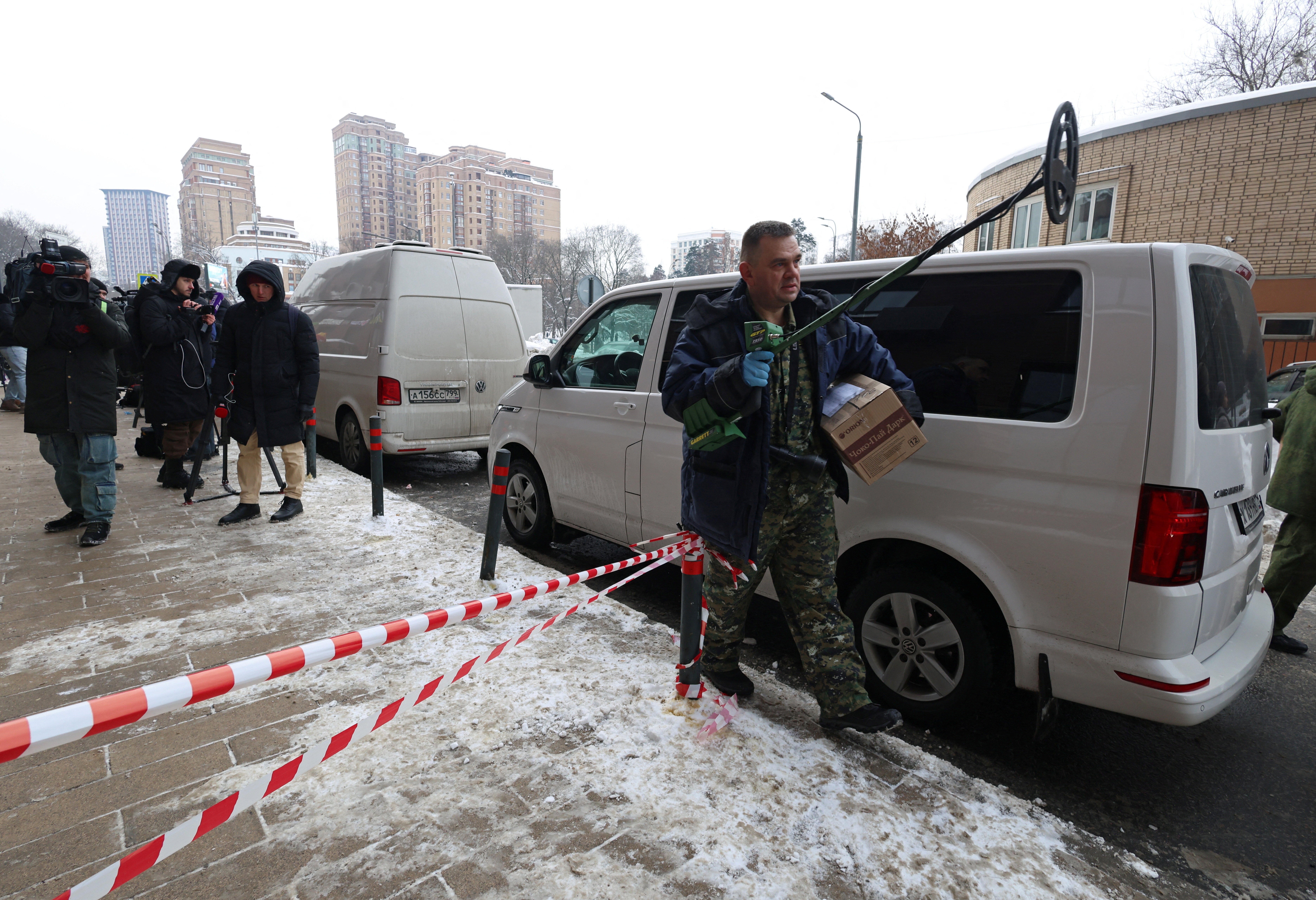 An investigator works outside a residential building.