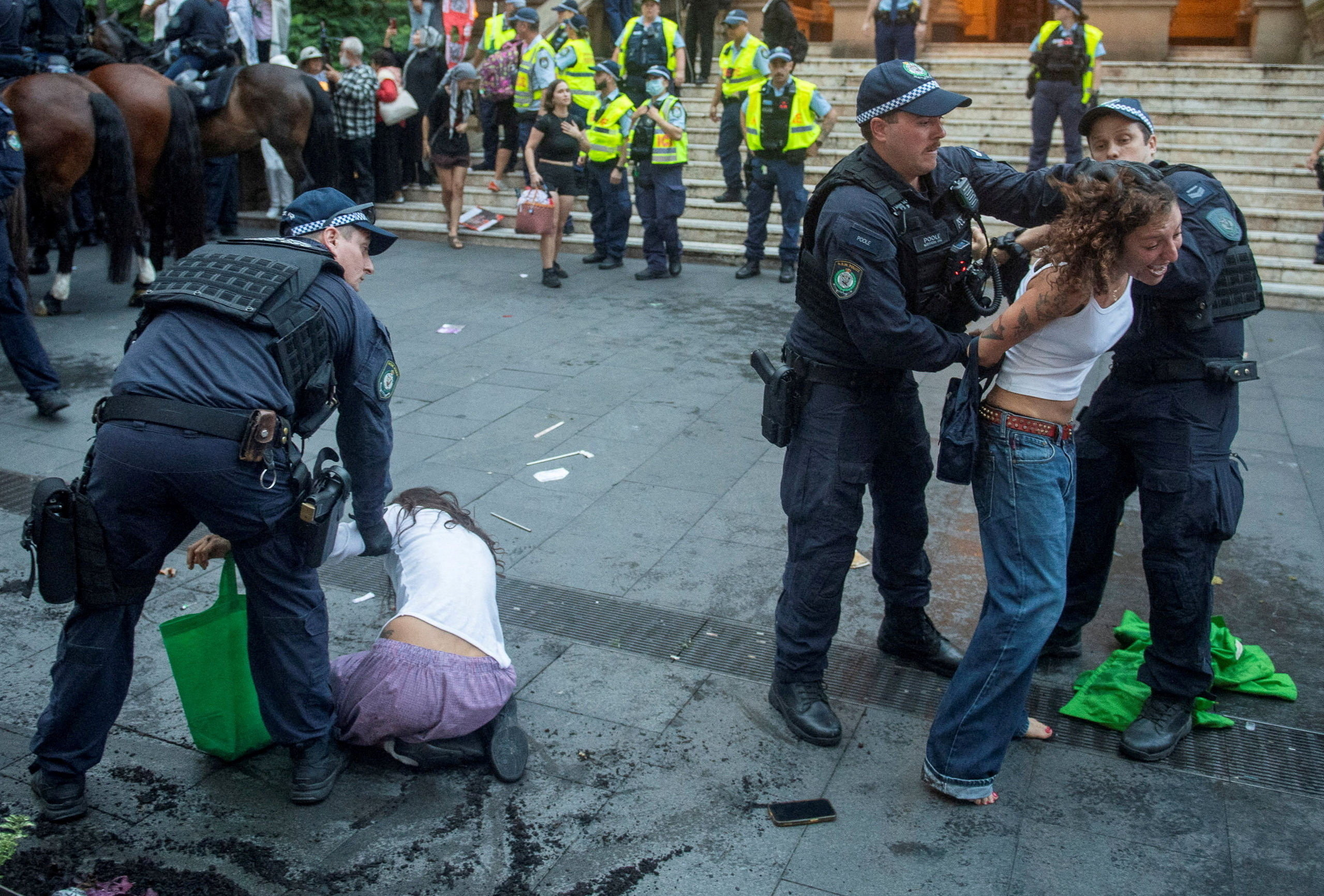 Police officers remove demonstrators.