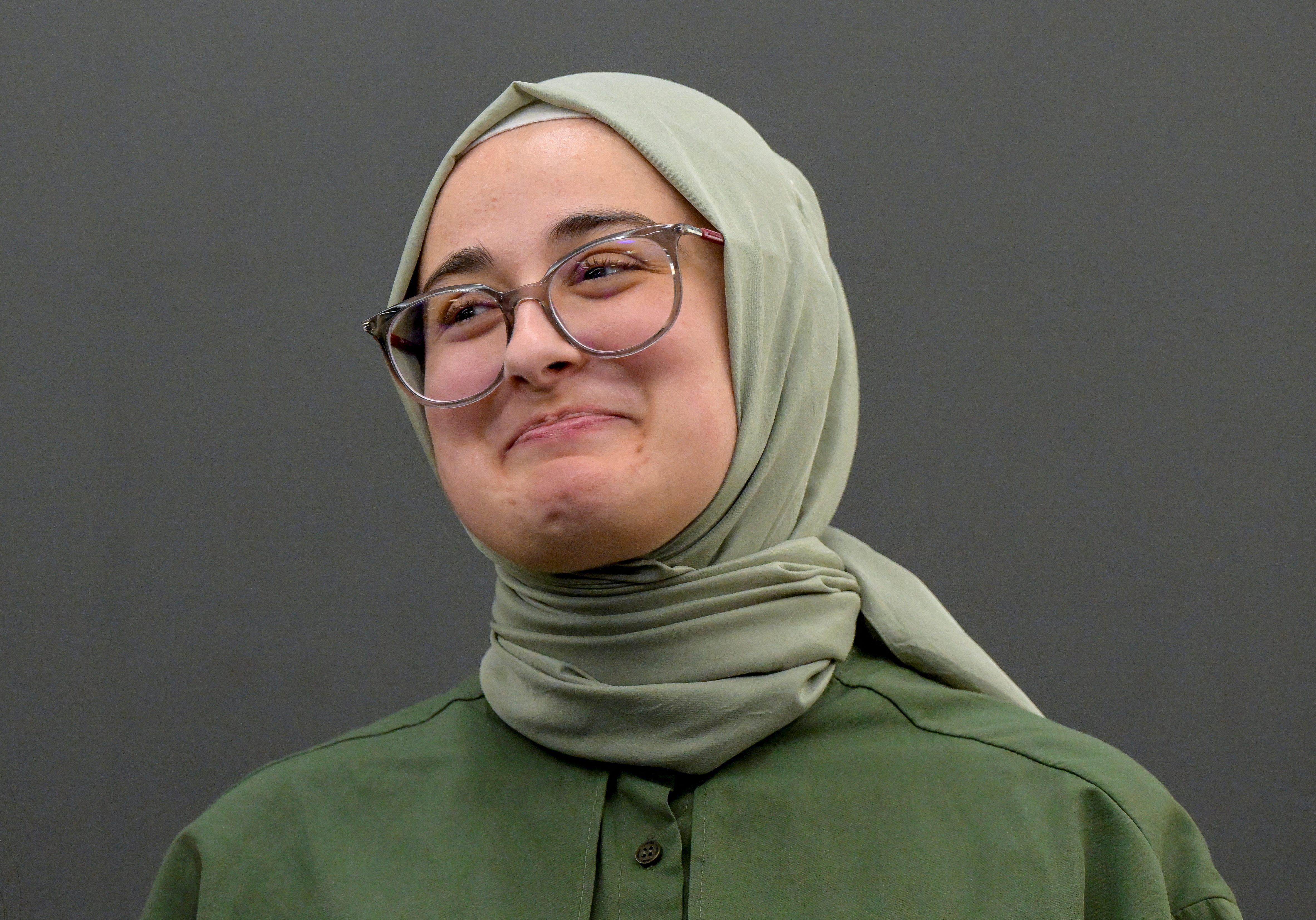 Tufts University student Rumeysa Ozturk, of Turkiye, smiles in a news conference.