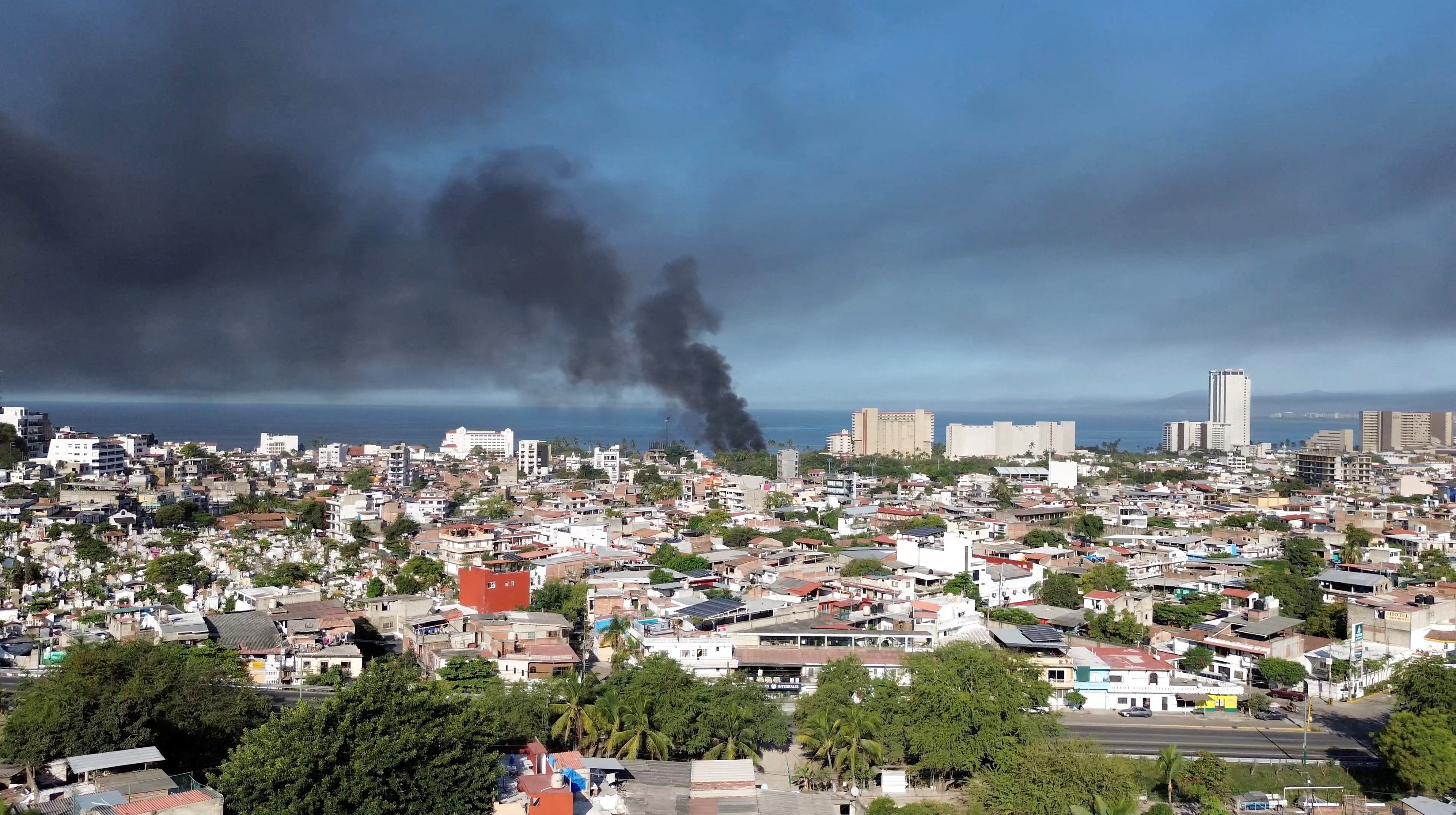 Smoke billows amid a wave of violence, with torched vehicles and gunmen blocking highways in more than half a dozen states, following a military operation in which a government source said Mexican drug lord Nemesio Oseguera, known as "El Mencho," was killed, in Puerto Vallarta, Jalisco, Mexico,