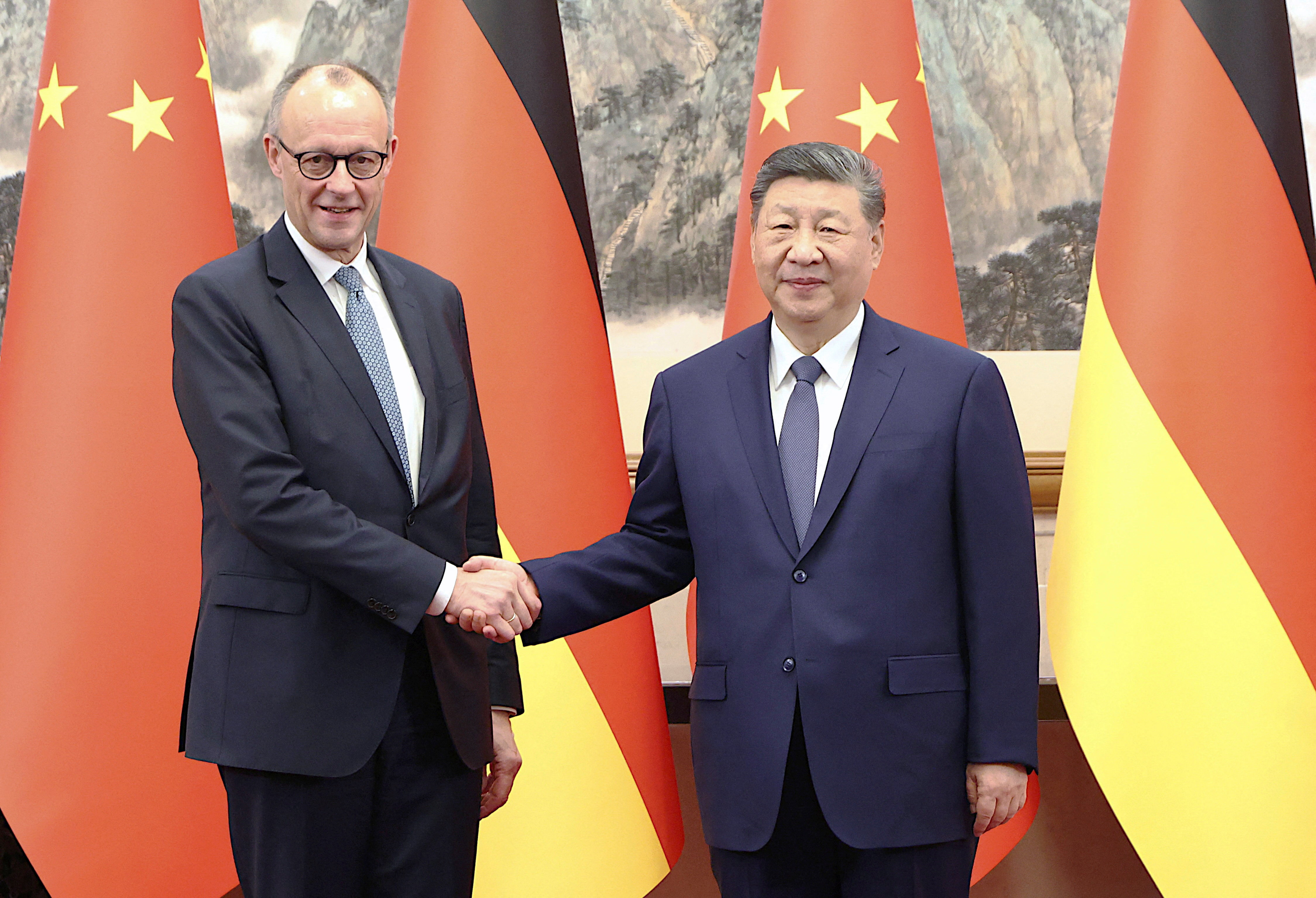 China's President Xi Jinping and Germany's Chancellor Friedrich Merz shake hands.