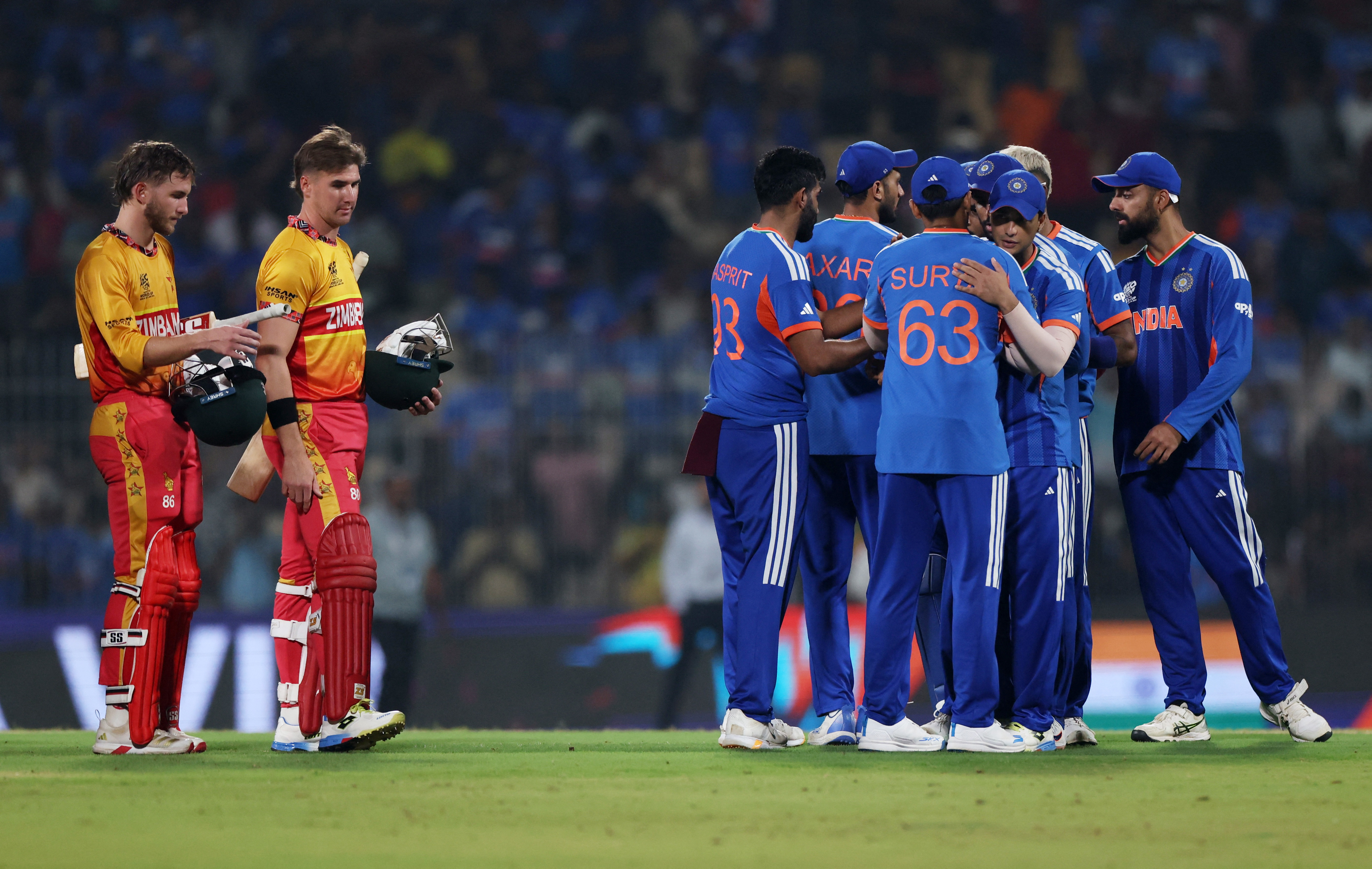 Cricket - ICC Men's T20 World Cup 2026 - Super 8 - India v Zimbabwe - MA Chidambaram Stadium, Chennai, India - February 26, 2026 India's Jasprit Bumrah celebrates with teammates as Zimbabwe's Brian Bennett and Brad Evans look dejected after the match REUTERS/Priyanshu Singh