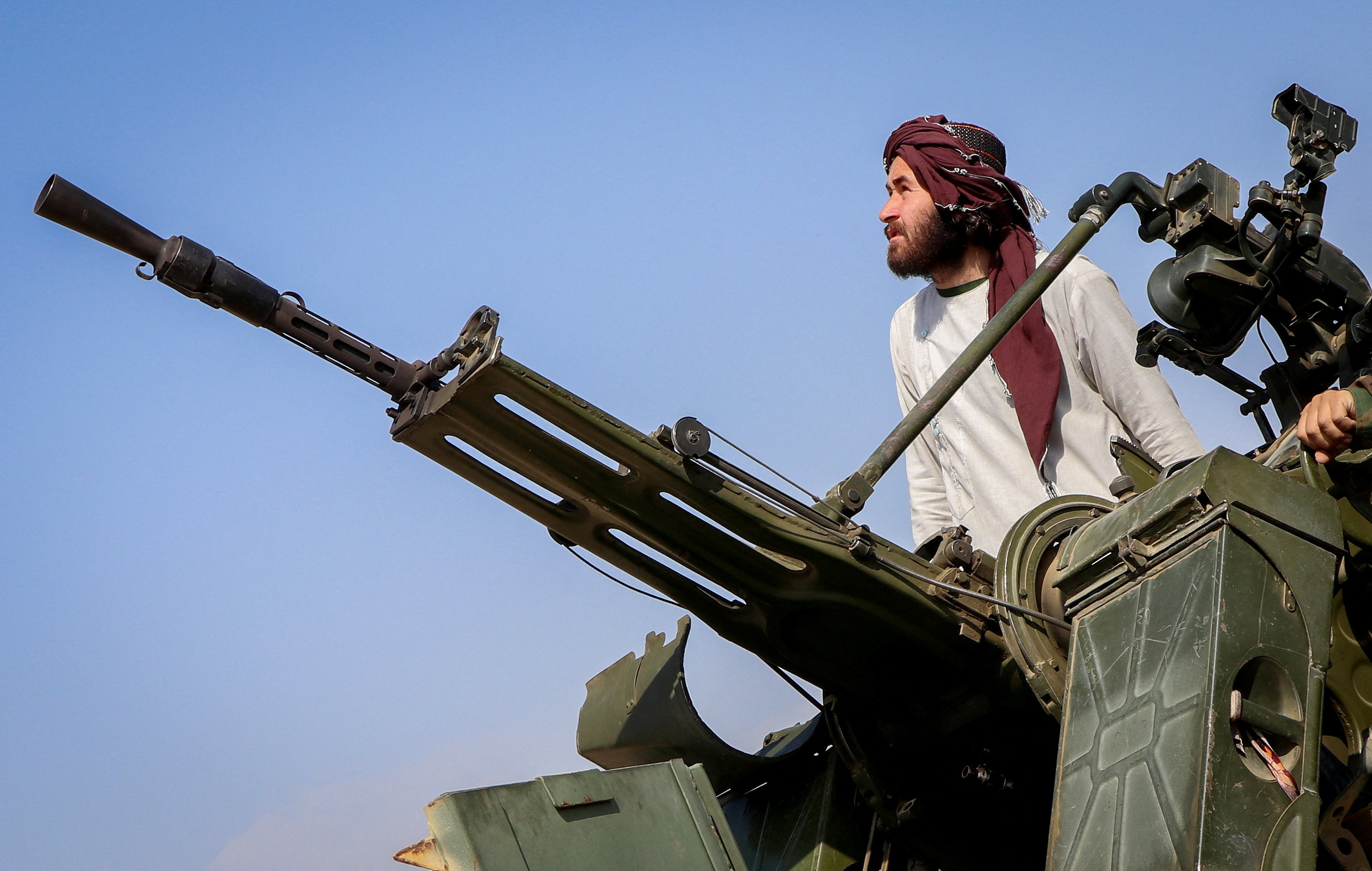 A Taliban soldier stands next to an anti-aircraft gun while on lookout for Pakistani fighter jets.