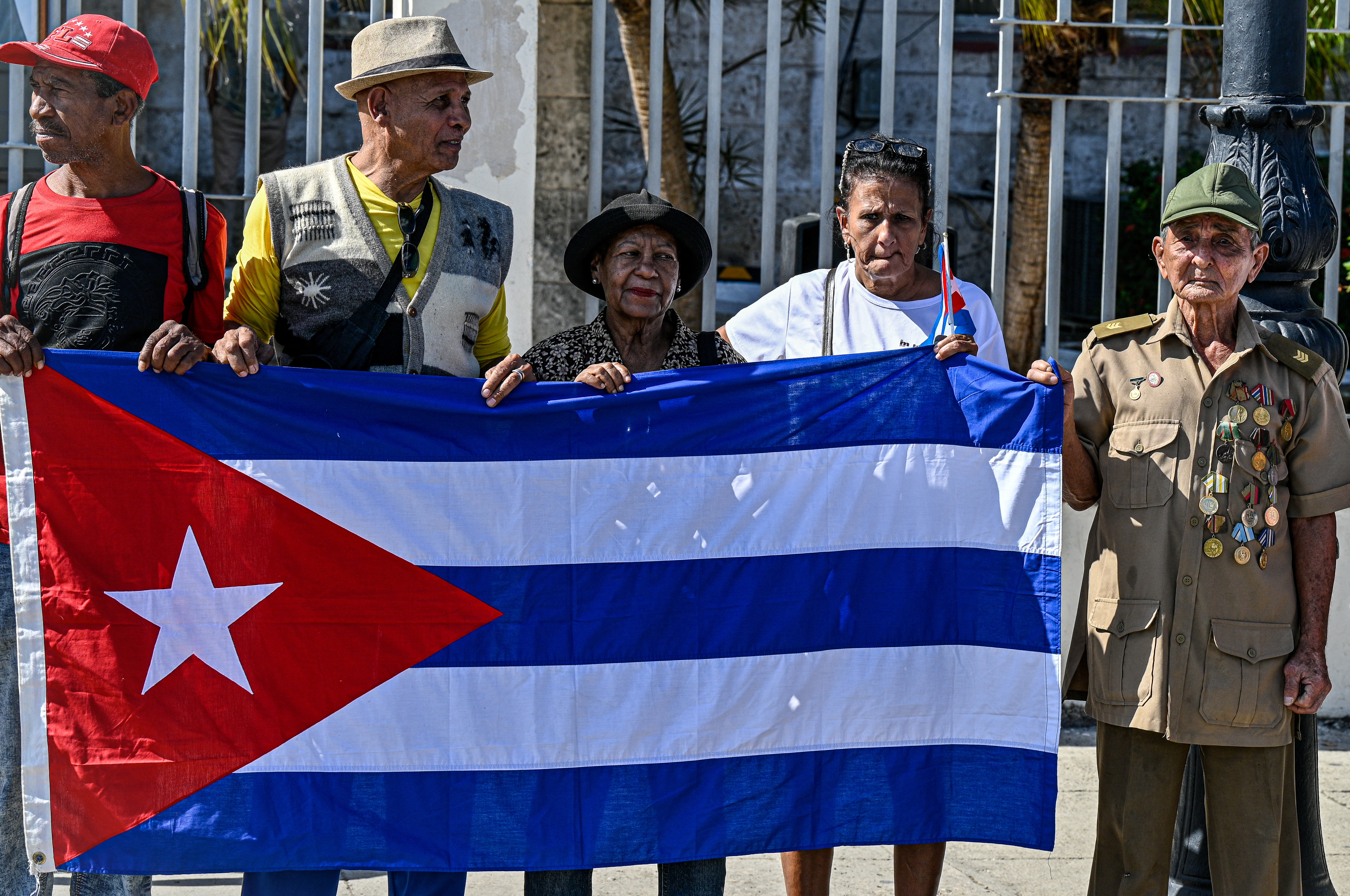 Cubans hold a national flag during the 67th anniversary of the Caravan of Freedom to commemorate Fidel Castros historic entry into the city which marked the start of the Cuban Revolution, in Havana on January 8, 2026. (Photo by ADALBERTO ROQUE / AFP)