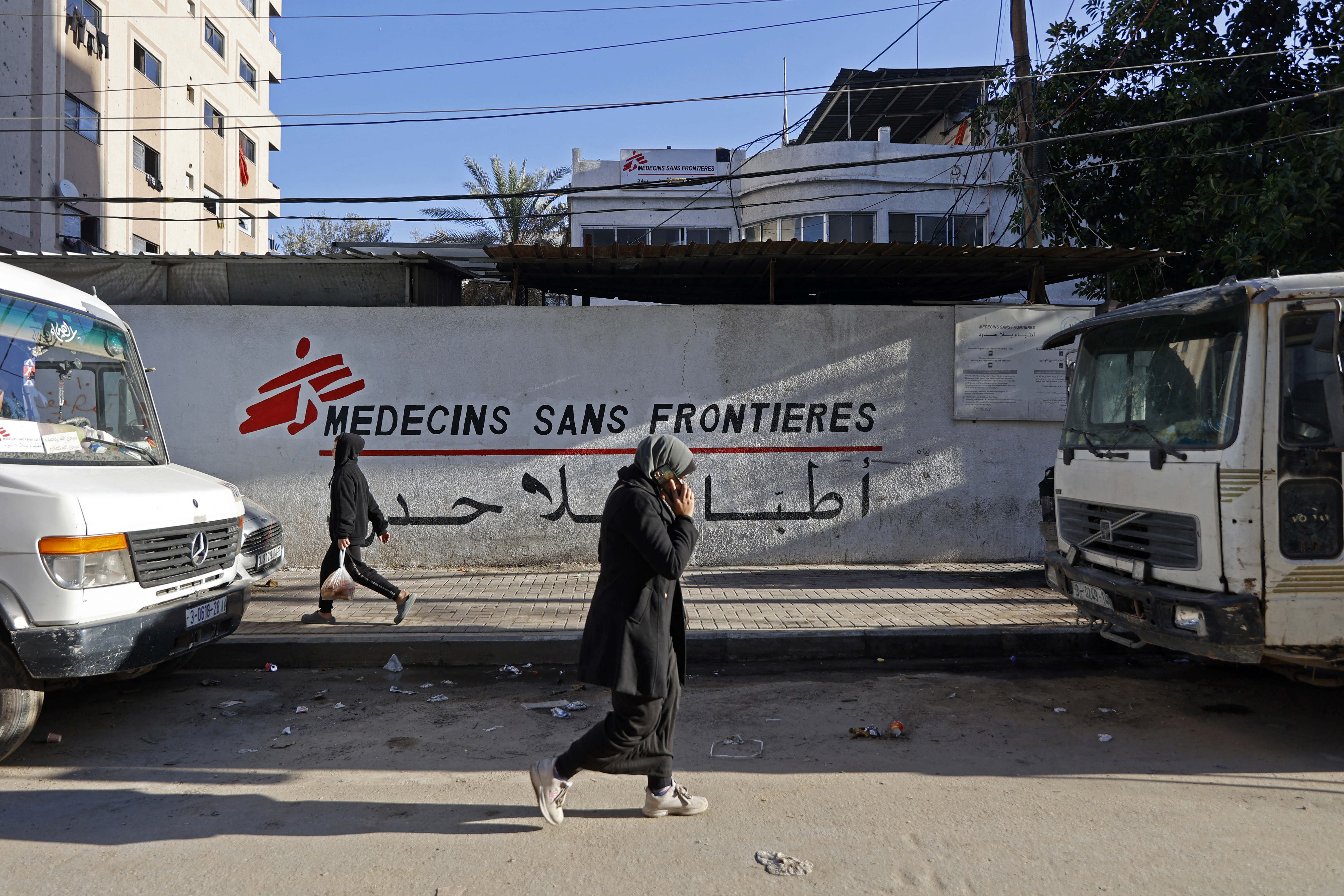 Palestinians walk past the clinic of Doctors Without Borders (MSF) in the al-Rimal neighbourhood of Gaza City on January 11, 2026.
