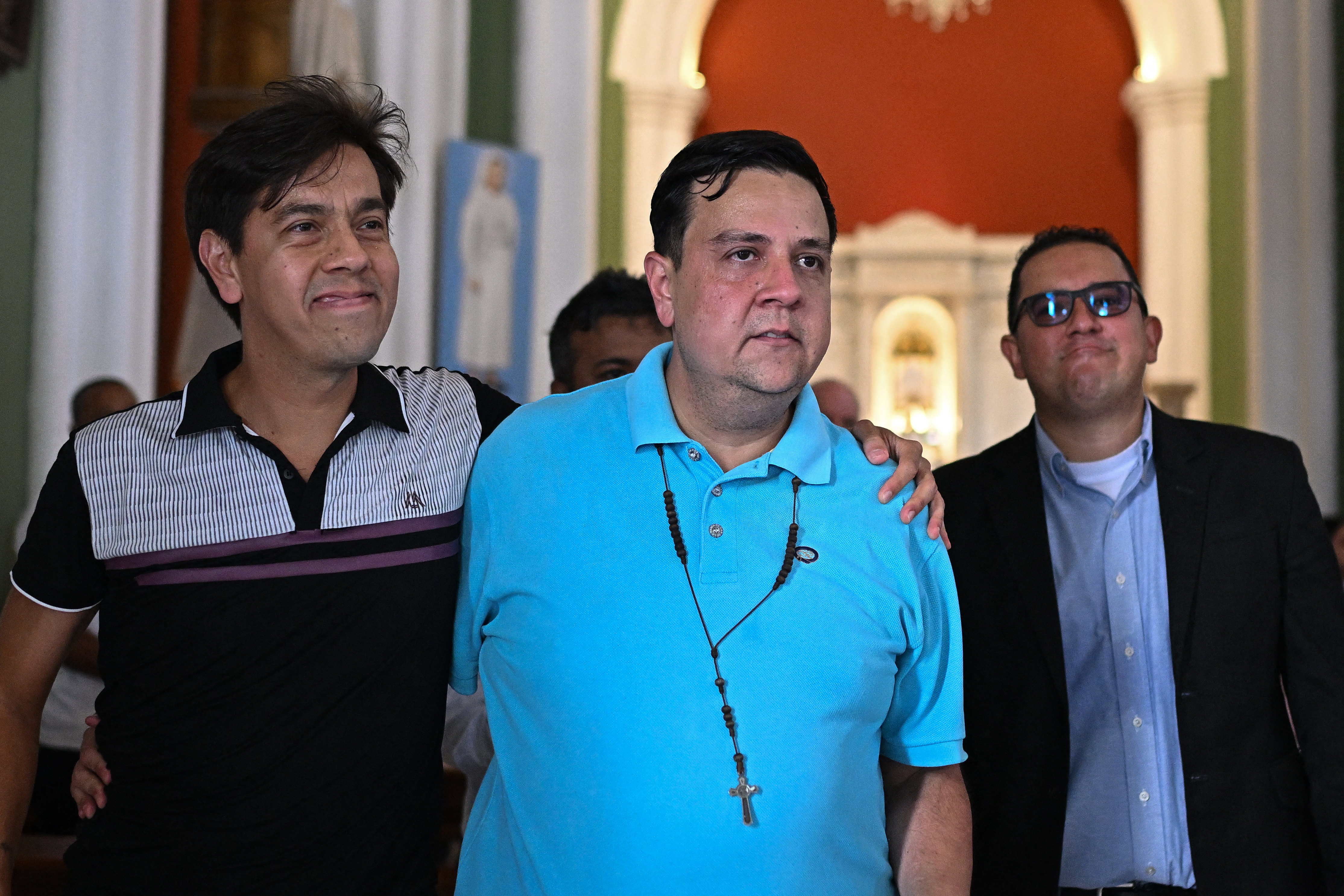 Human rights activist Javier Tarazona (C) is greeted by his brother Jose Rafael Tarazona (L) and lawyer Miguel Forero after his release from prison at La Candelaria church in Caracas on February 1, 2026. Renowned Venezuelan human rights activist Javier Tarazona was freed on February 1st after more than four years in prison on charges including terrorism and treason, his brother told AFP. (Photo by Federico PARRA / AFP)