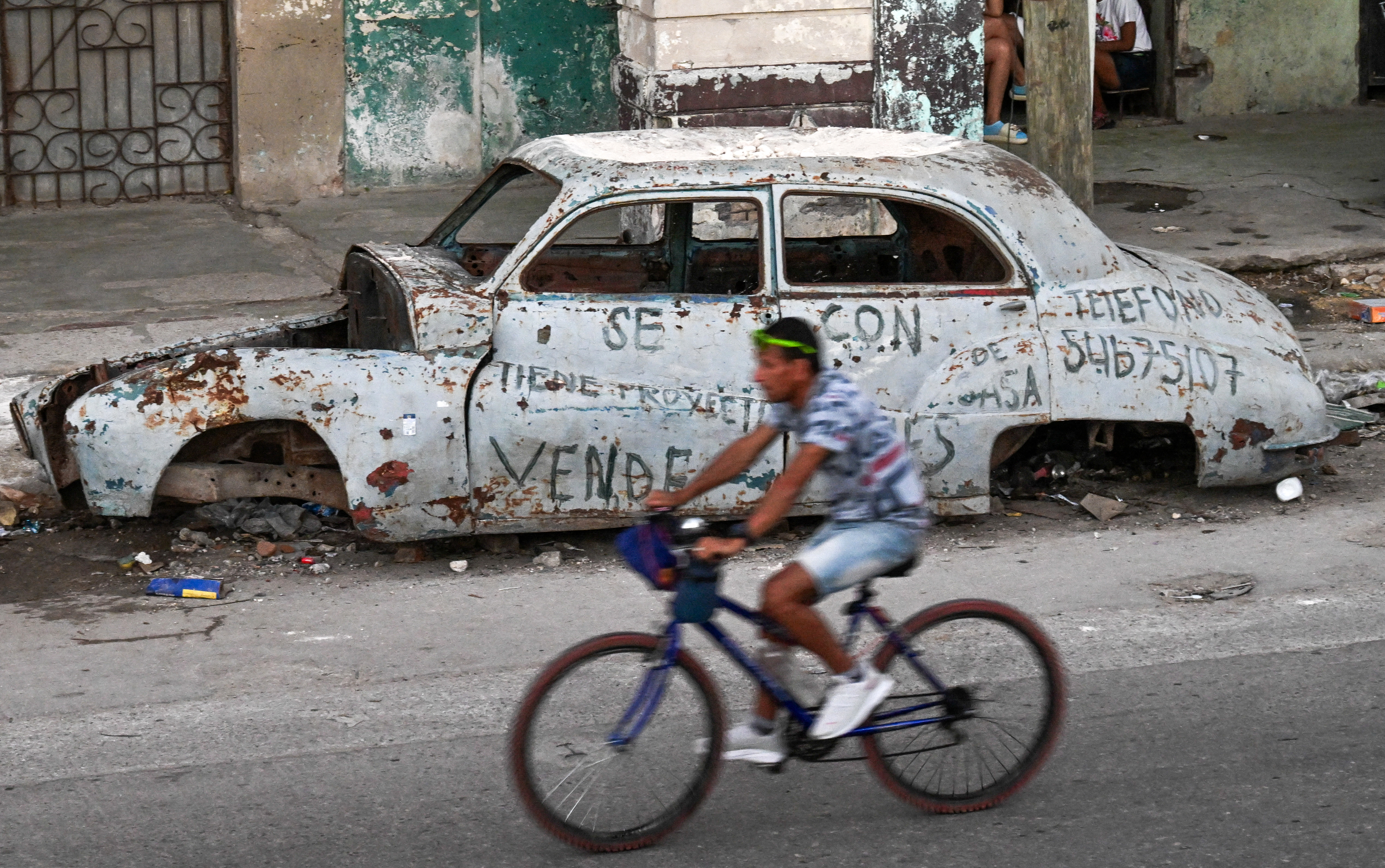 A man rides past an abandoned car in Havana on February 4, 2026.