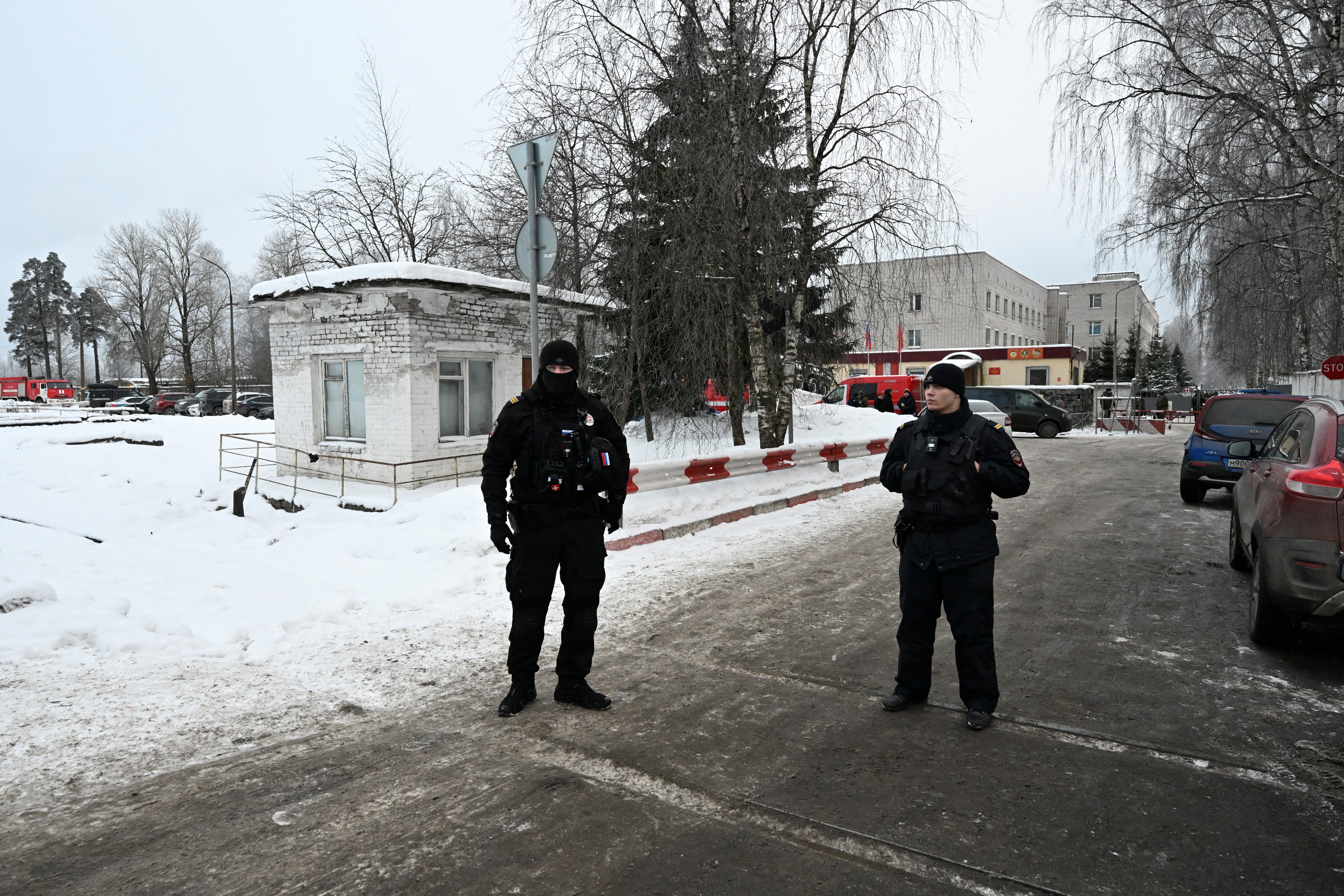 Police officers stand guard outside the grounds of an army base where a military police building collapsed, in Sertolovo in the Leningrad region on February 17, 2026. Local media reported that three people died in the incident, citing emergency services. (Photo by Olga MALTSEVA / AFP)