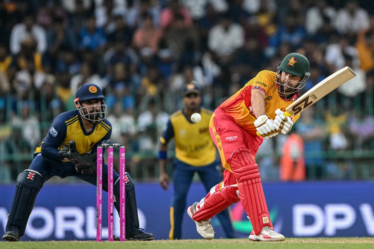 Zimbabwe's Ryan Burl (R) plays a shot as Sri Lanka's wicketkeeper Kusal Mendis watches during the 2026 ICC Men's T20 Cricket World Cup group stage match between Sri Lanka and Zimbabwe