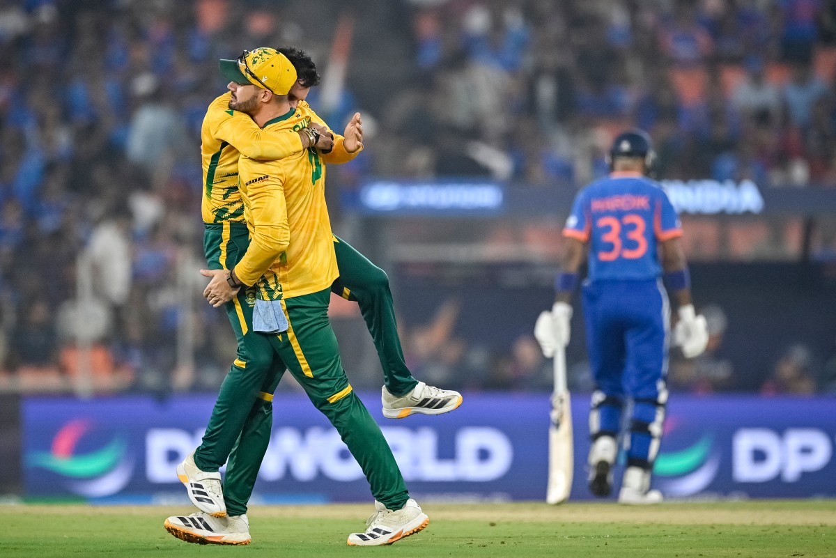 South Africa's Keshav Maharaj (L back) celebrates with captain Aiden Markram after taking the wicket of India's Hardik Pandya (R) during the 2026 ICC Men's T20 Cricket World Cup Super Eights match between India and South Africa at the Narendra Modi Stadium in Ahmedabad on February 22, 2026. (Photo by Shammi MEHRA / AFP)
