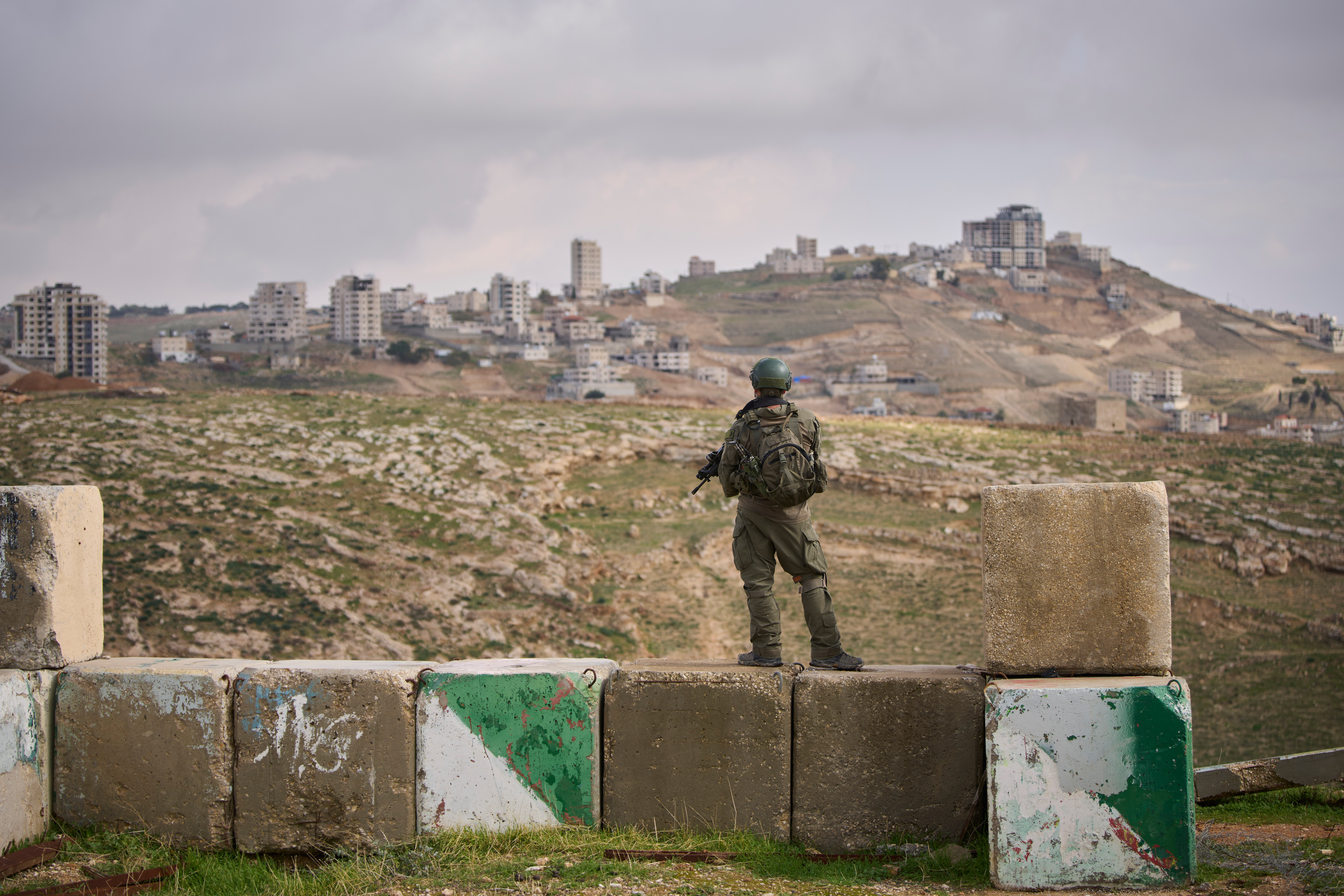 An Israeli soldier stands guard during the inauguration ceremony for the newly legalized Jewish settlement of Yatziv