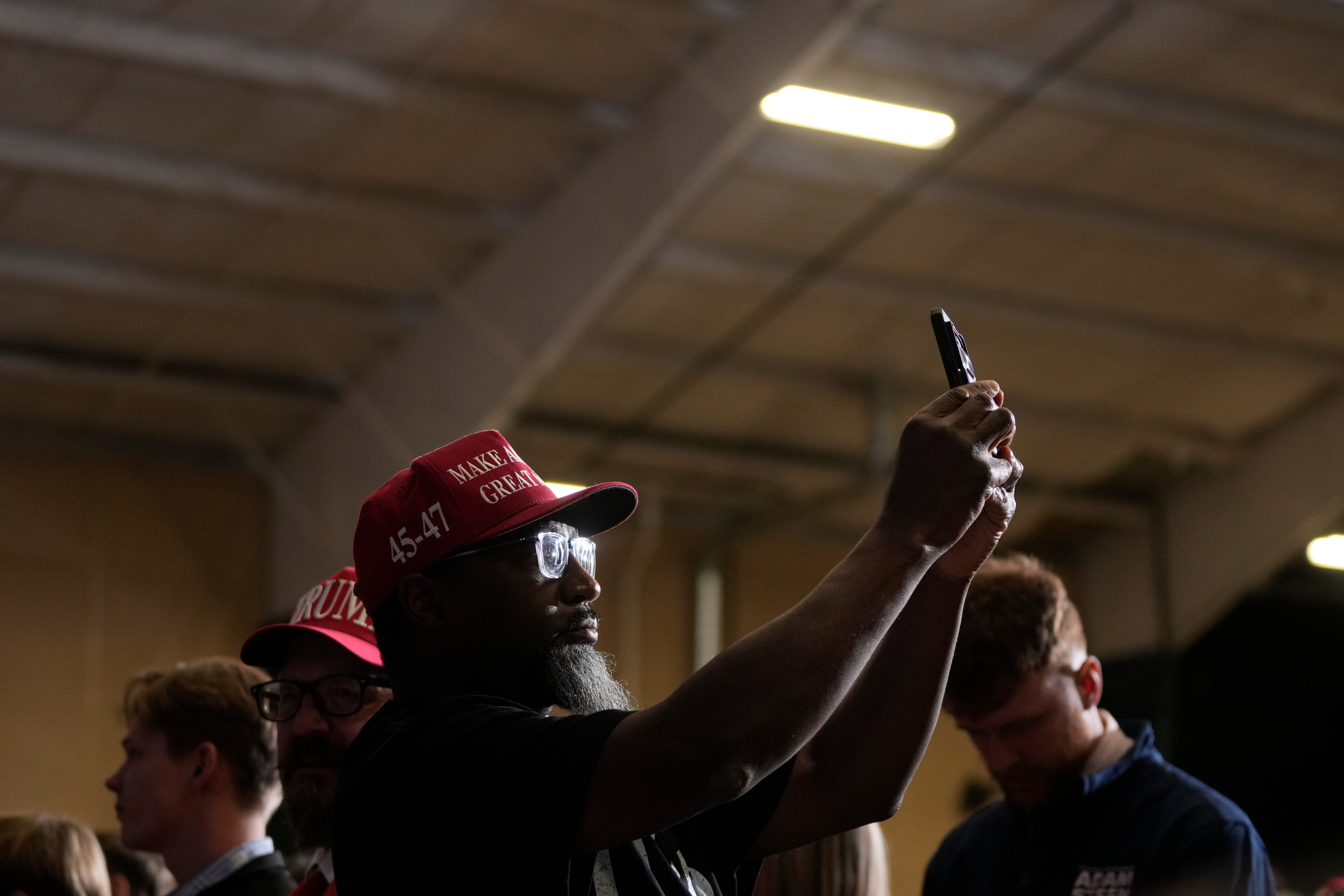 A supporter takes a photo of Trump on a cellphone