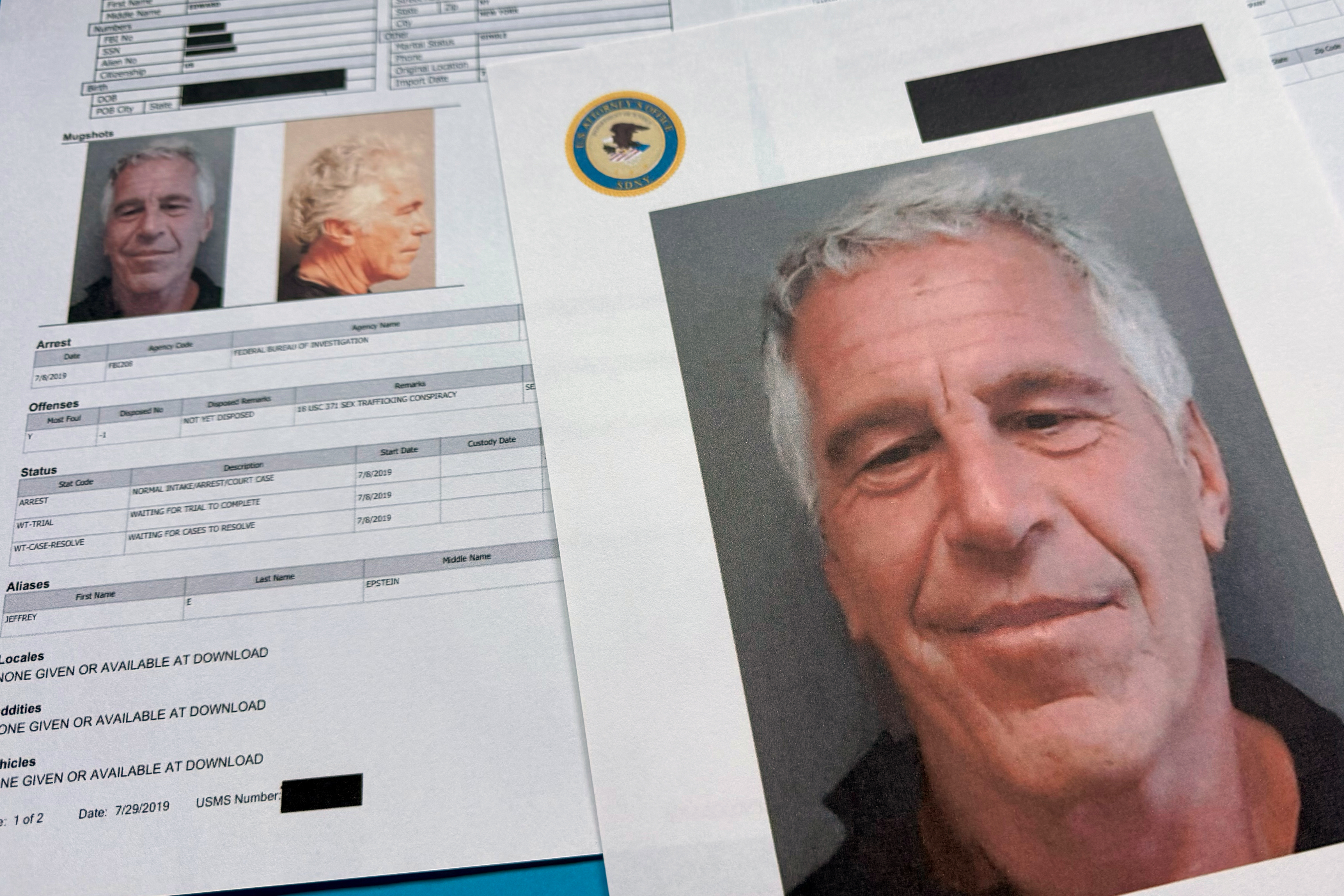 Documents that were included in the US Department of Justice release of the Jeffrey Epstein files are shown in a photograph.