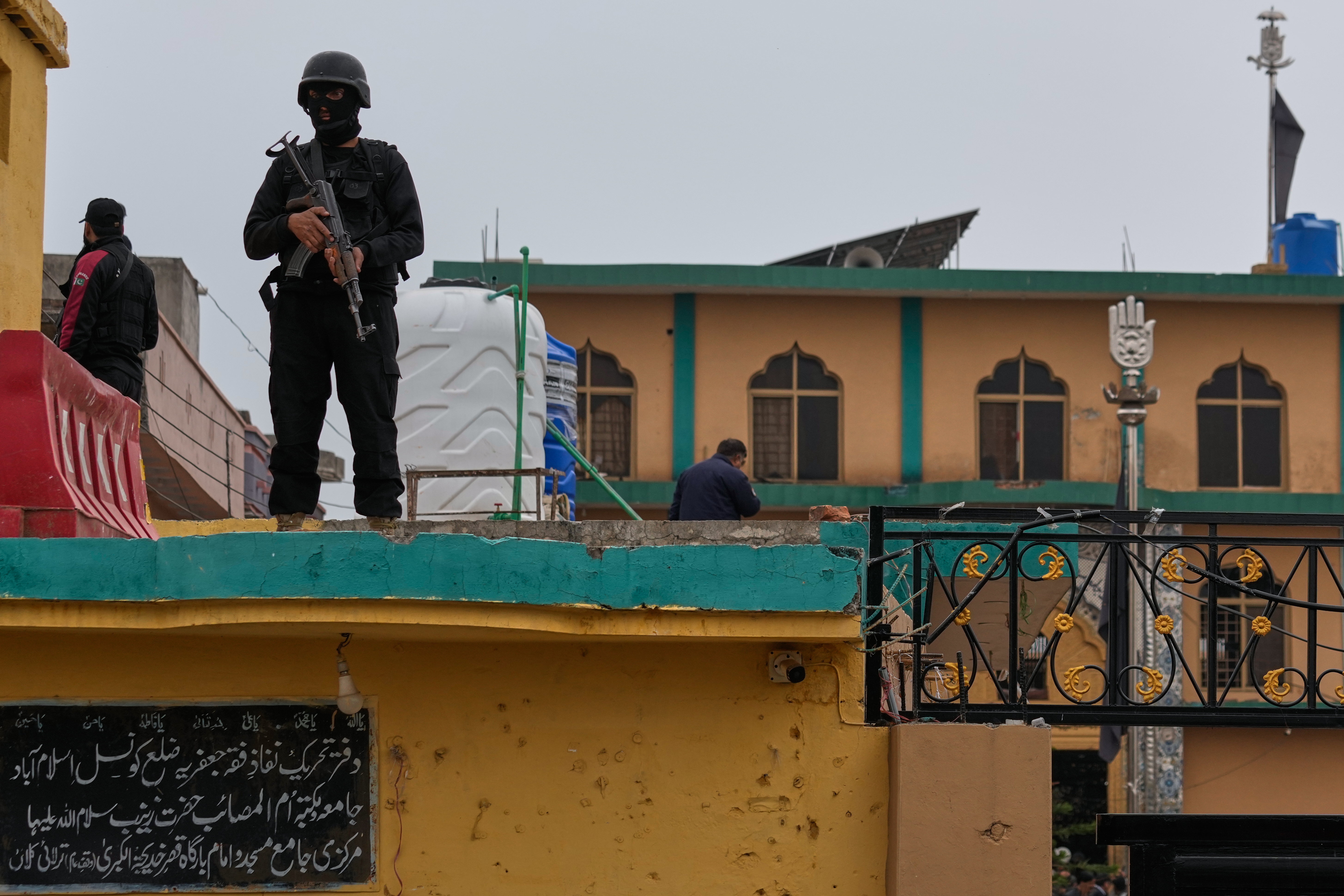 Police commandos take positions at the site of a bomb explosion.