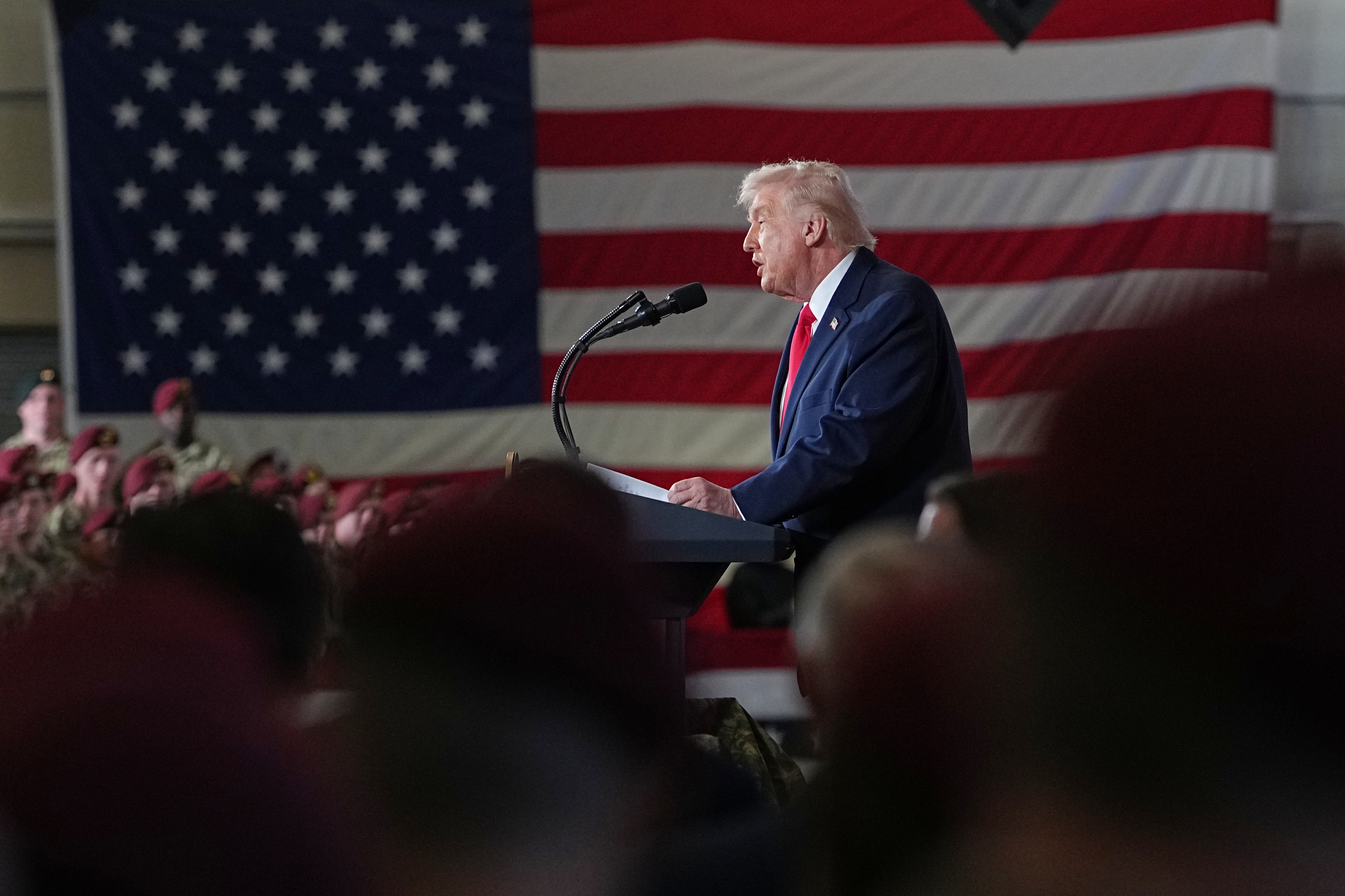 Donald Trump speaks in front of a US flag