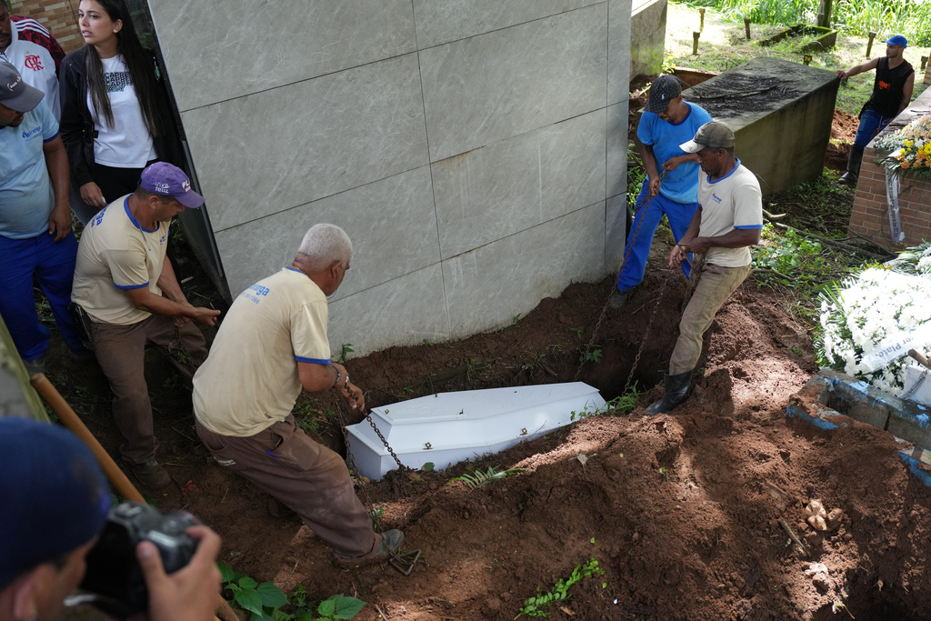 A coffin is lowered into a grave at a funeral