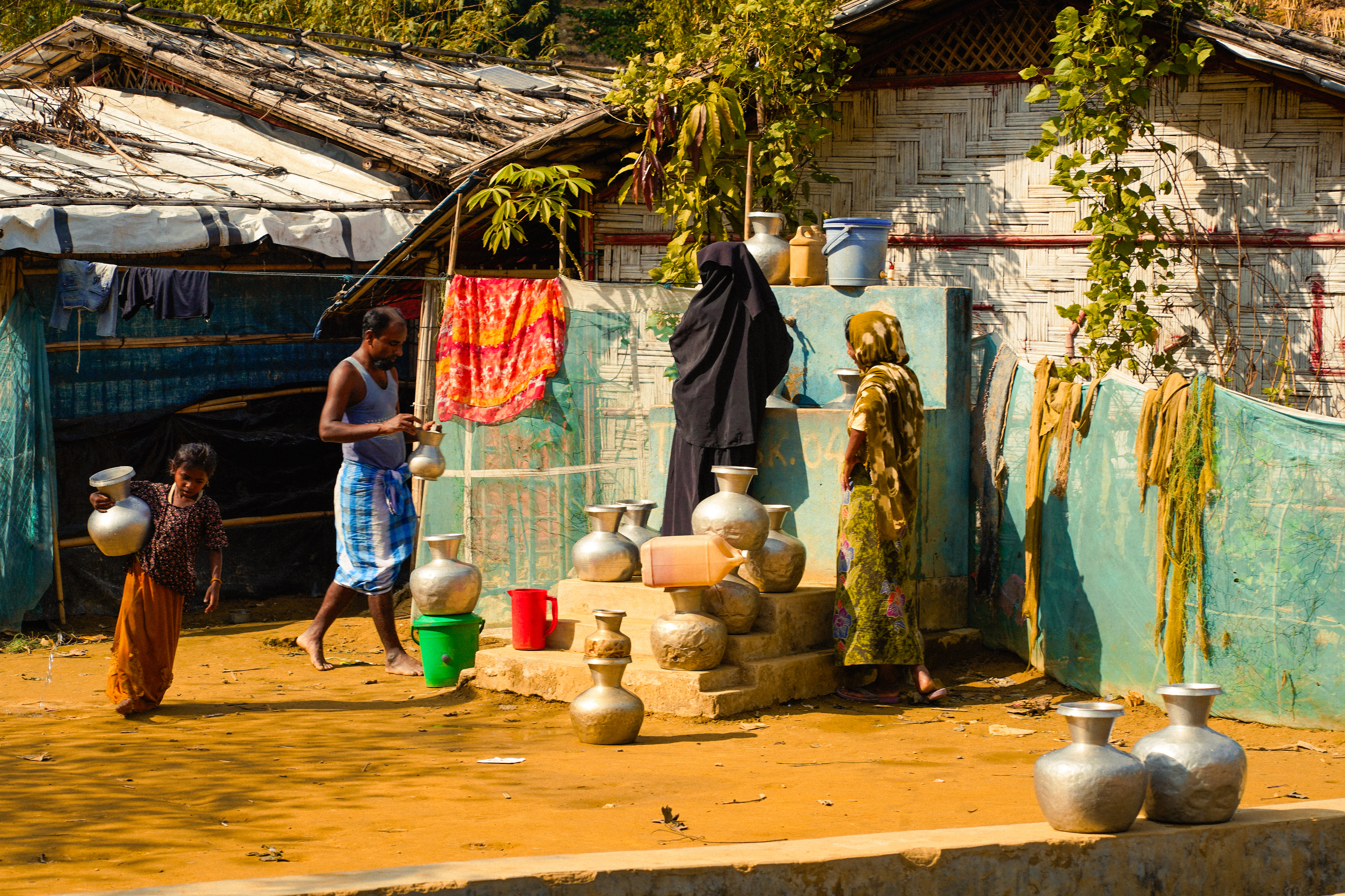 A Rohingya family outside their temporary home in a camp in Cox's Bazar, Bangladesh [Sahat Zia/Al Jazeera]