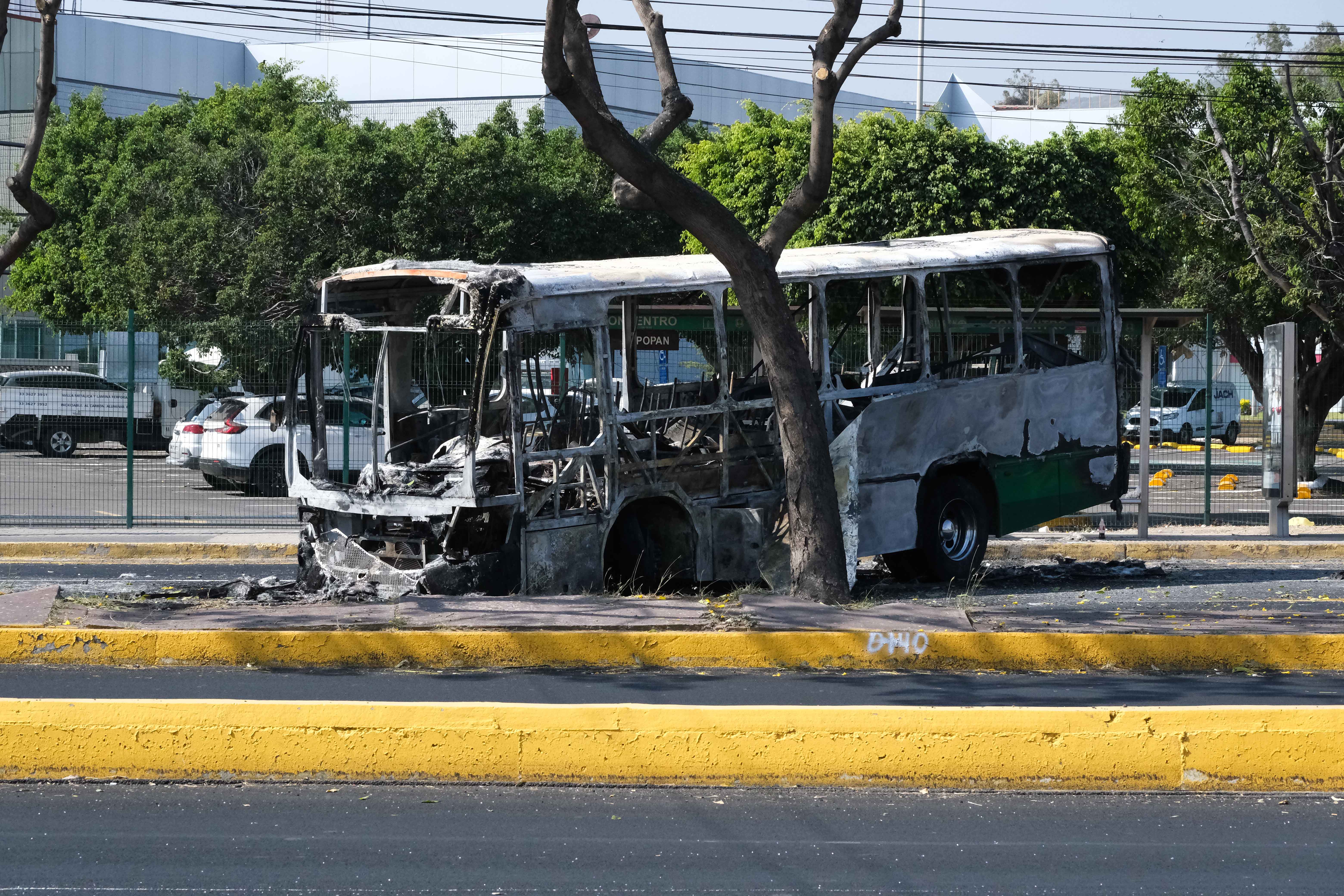 A burned bus blocks a highway leading to Estadio Akron in Zapopan, Jalisco, Mexico on February 22, 2026. [Casey Premoshis/Al Jazeera]