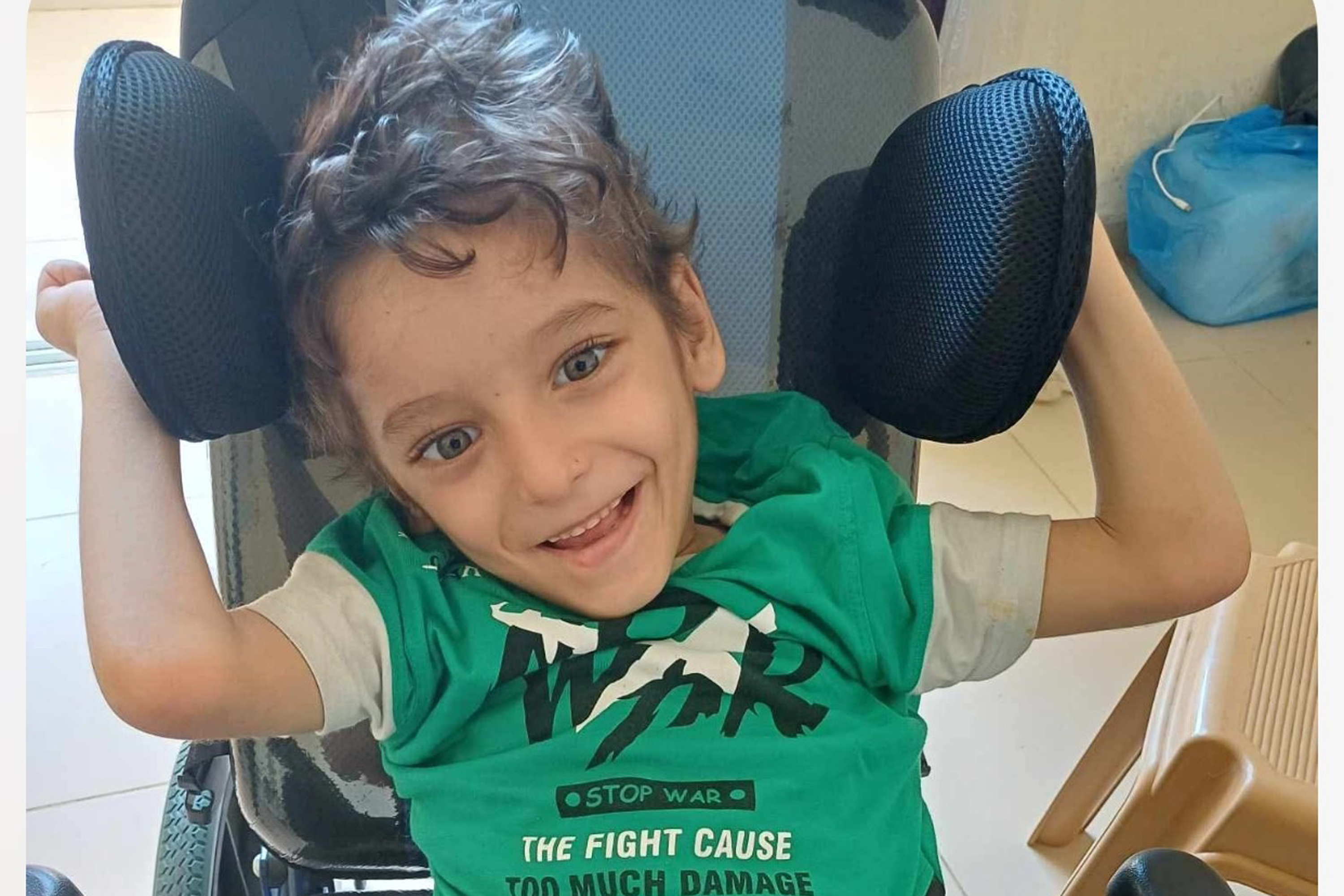 a photo of a little boy smiling to the camera in a green t-shirt