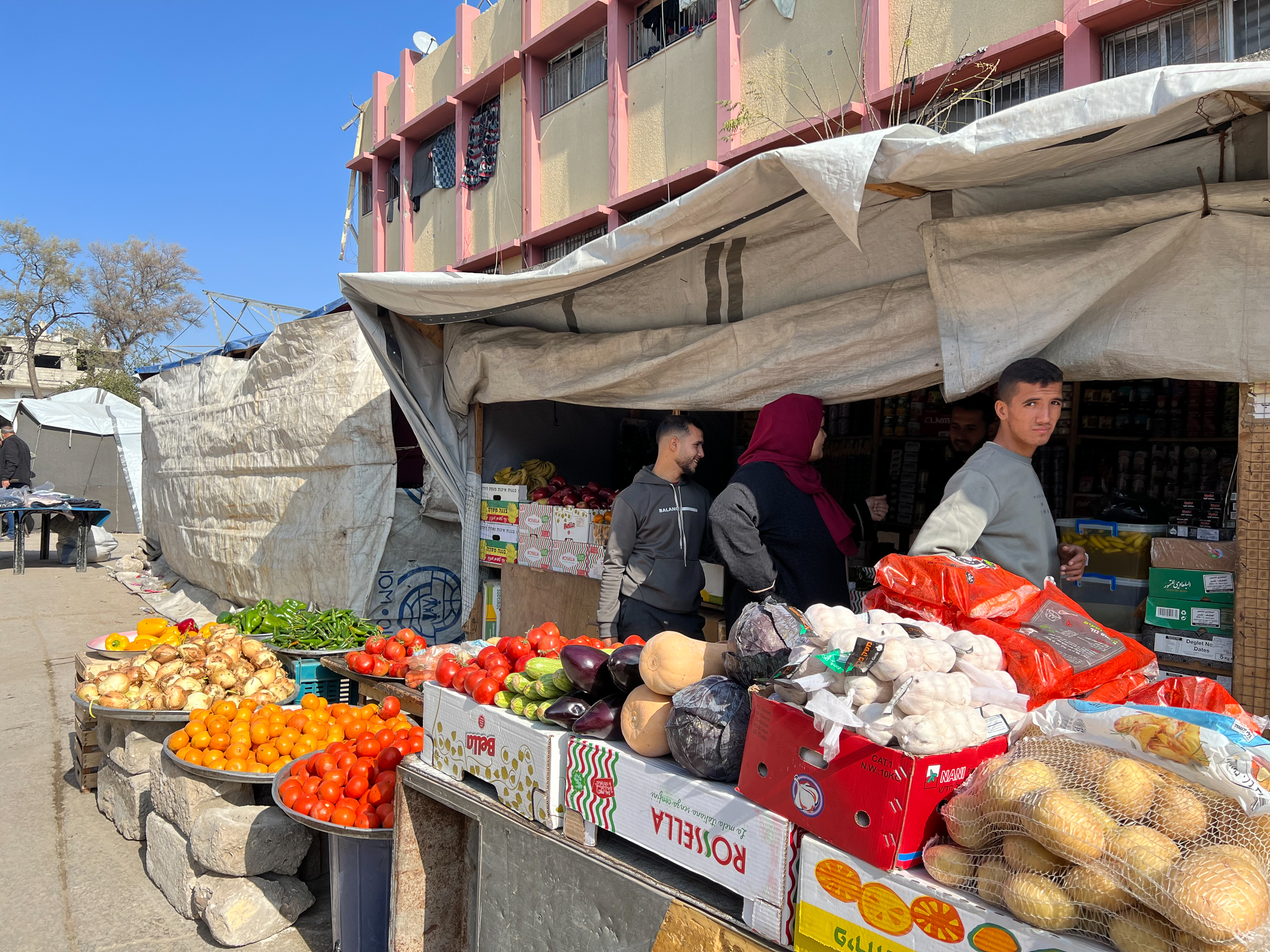 People buy groceries at a street stall.