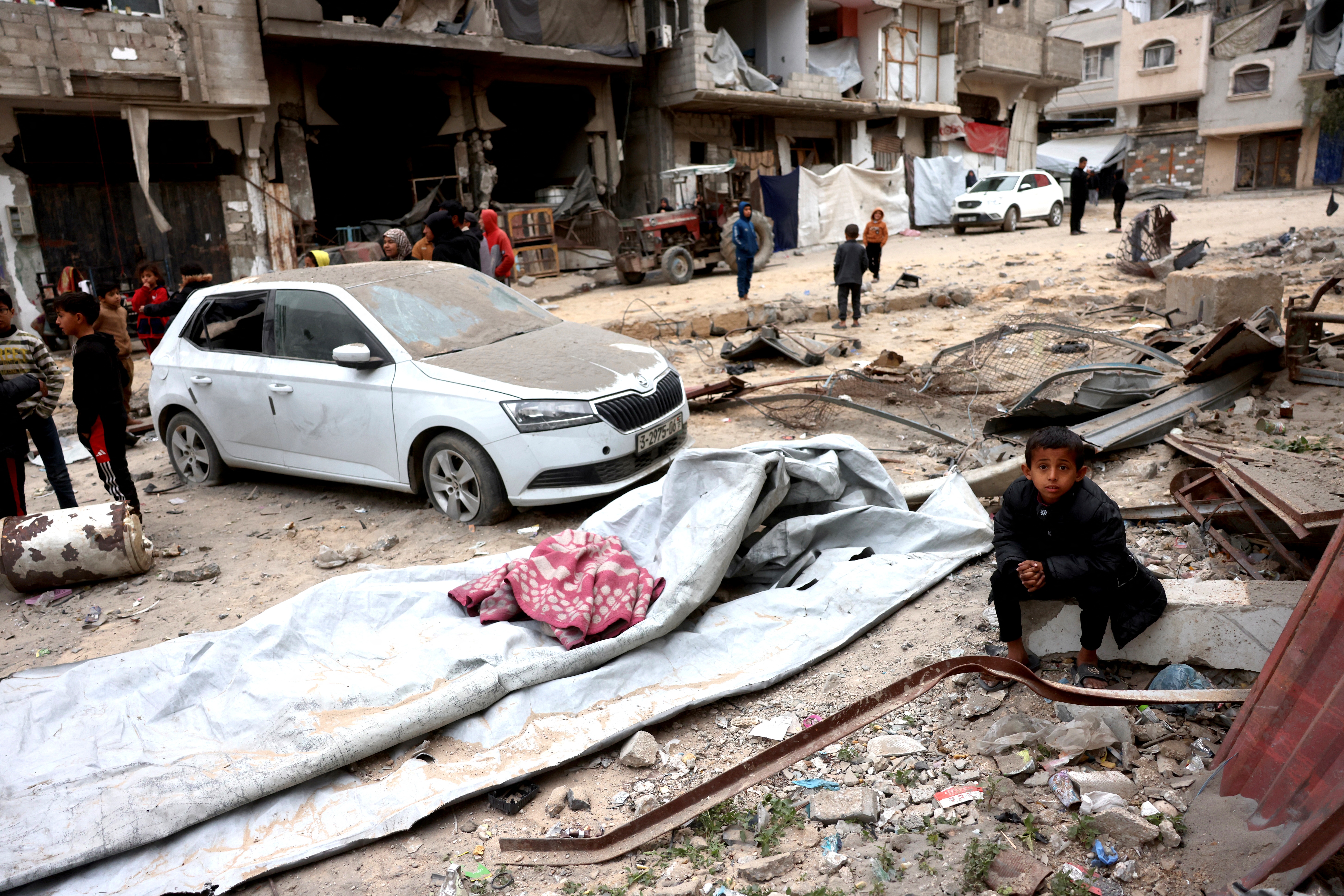 A displaced Palestinian boy sits on the rubble and debris after Israeli aircraft targeted a five floor house last night, in Khan Yunis, southern Gaza Strip on February 6, 2026.