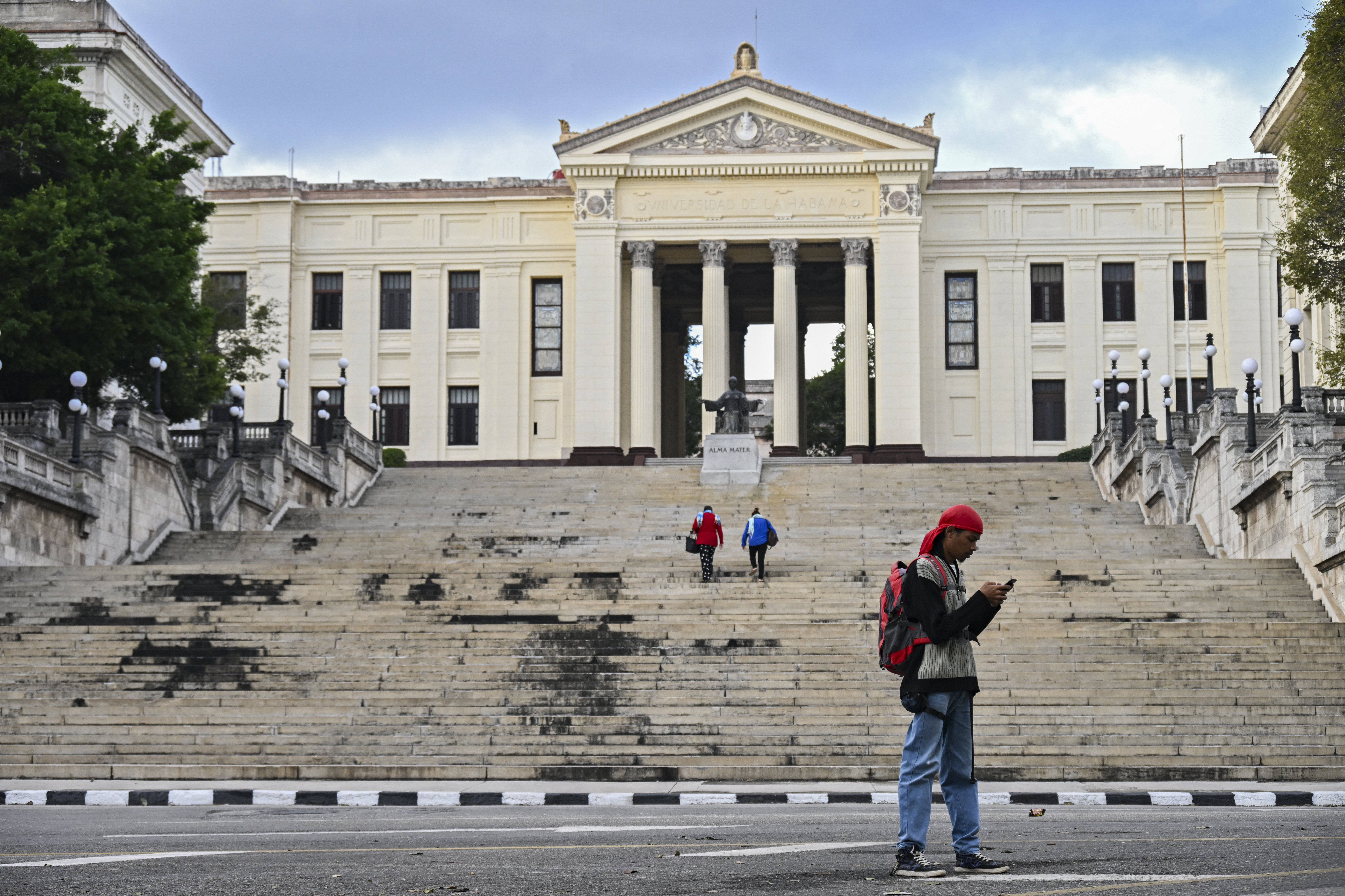 A young man uses his mobile phone in front of the University of Havana on February 6, 2026.