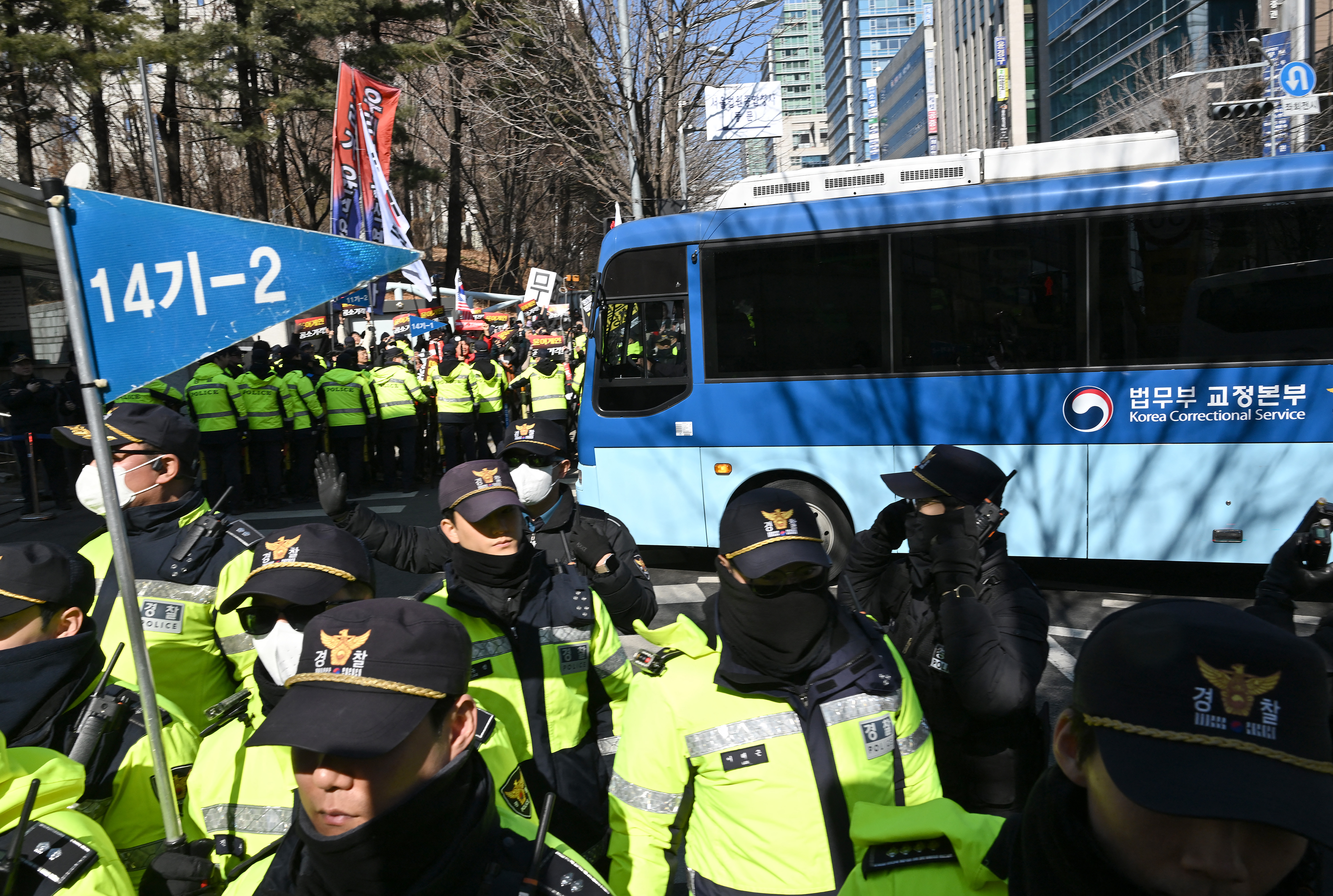 A blue bus believed to be transporting South Korea's impeached former president Yoon Suk Yeol arrives at the Seoul Central District Court in Seoul on February 19, 2026.