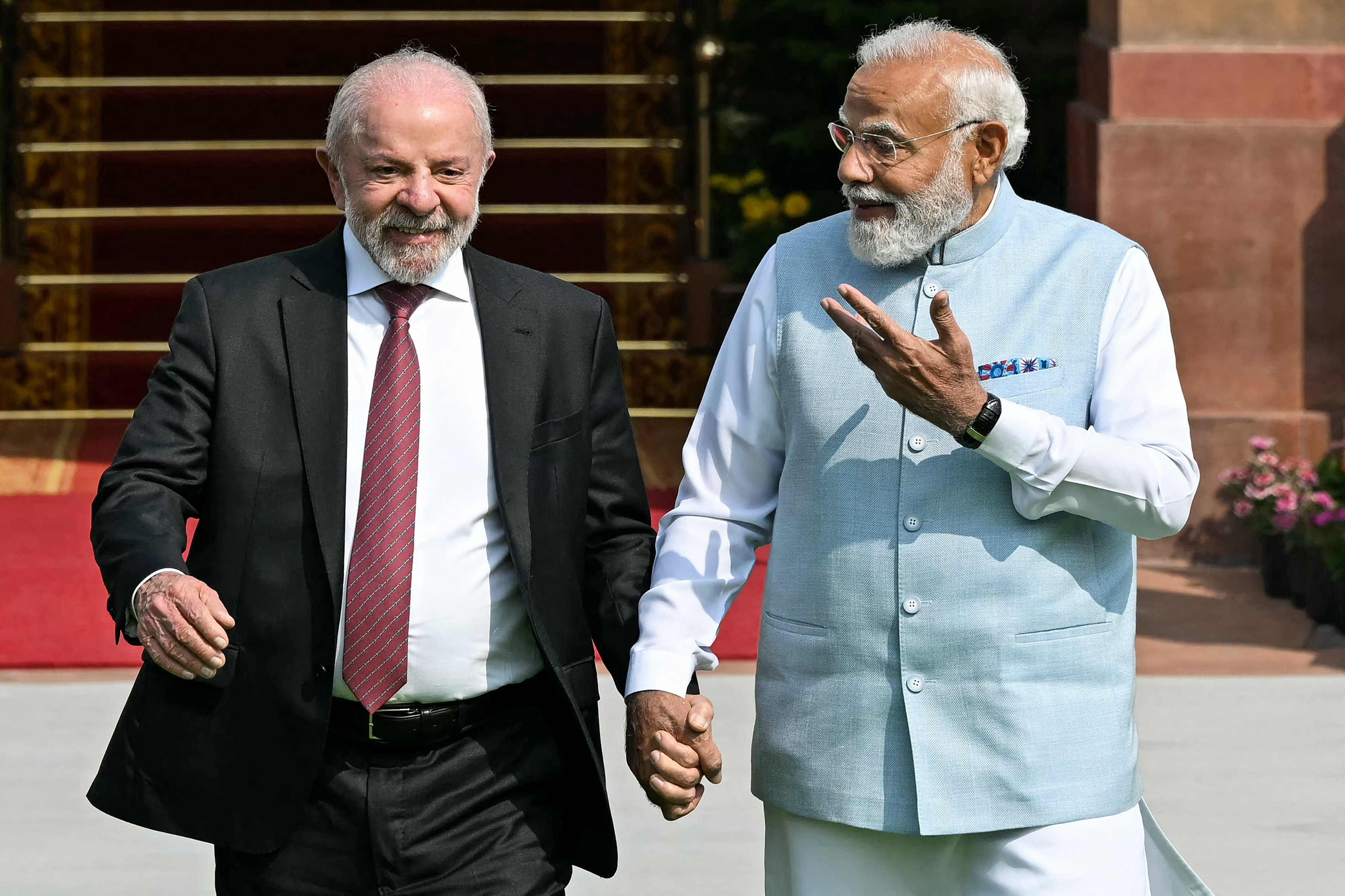 TOPSHOT - India's Prime Minister Narendra Modi (R) holds hands with Brazil's President Luiz Inacio Lula da Silva as they walk before their meeting at the Hyderabad House in New Delhi on February 21, 2026. (Photo by Sajjad HUSSAIN / AFP)